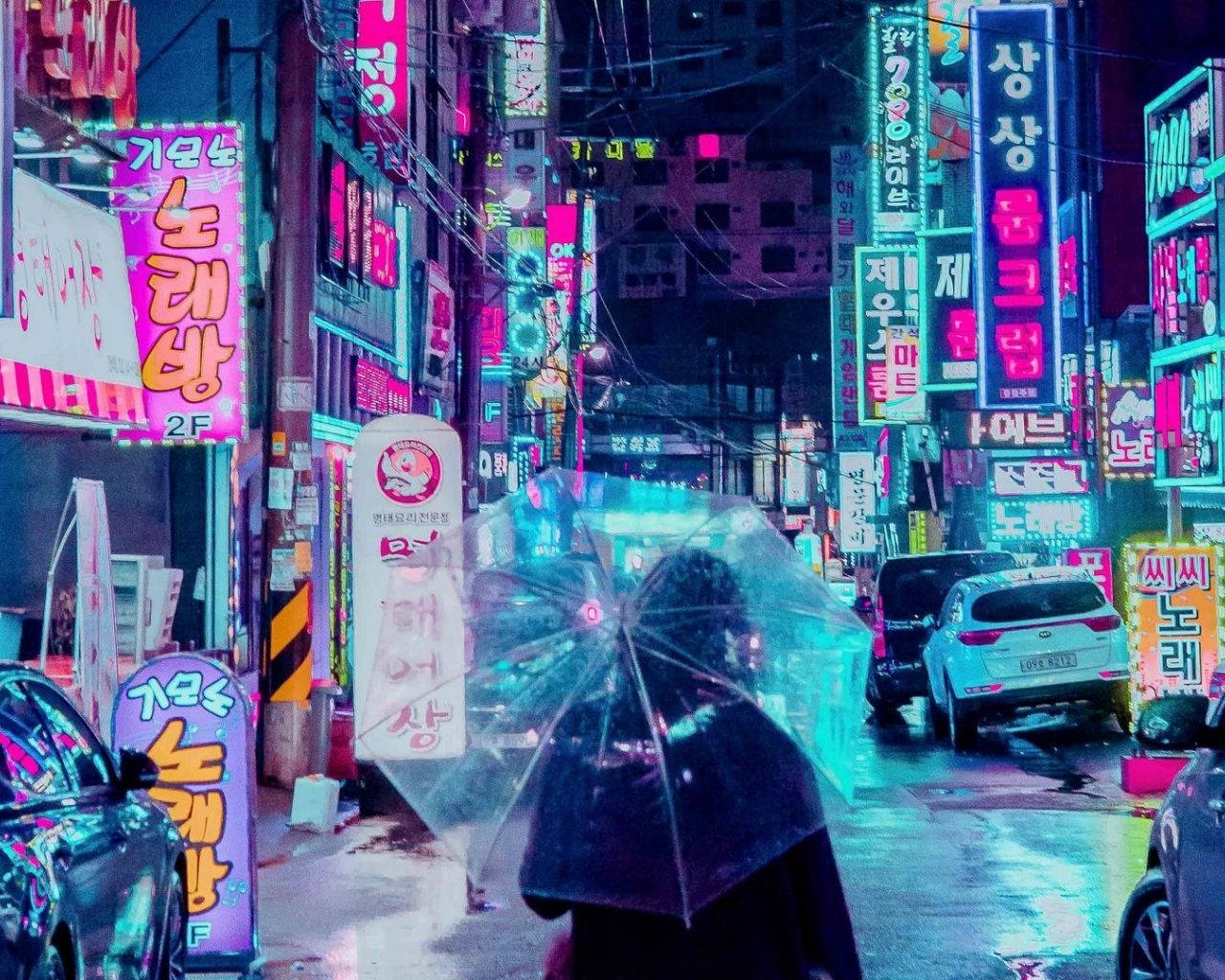 城市 桌布 壁紙 — 一個孤獨的身影撐著雨傘，在夜晚繁華的亞洲城市中，走過一條被雨水浸濕、霓虹燈閃爍的小巷。