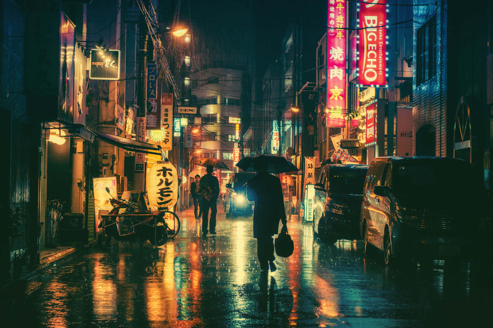 夜晚 桌布 壁紙 — 一個孤獨的身影撐著雨傘，在夜晚霓虹燈照亮、雨水浸濕的日本街道上行走，映照出鮮豔的招牌。