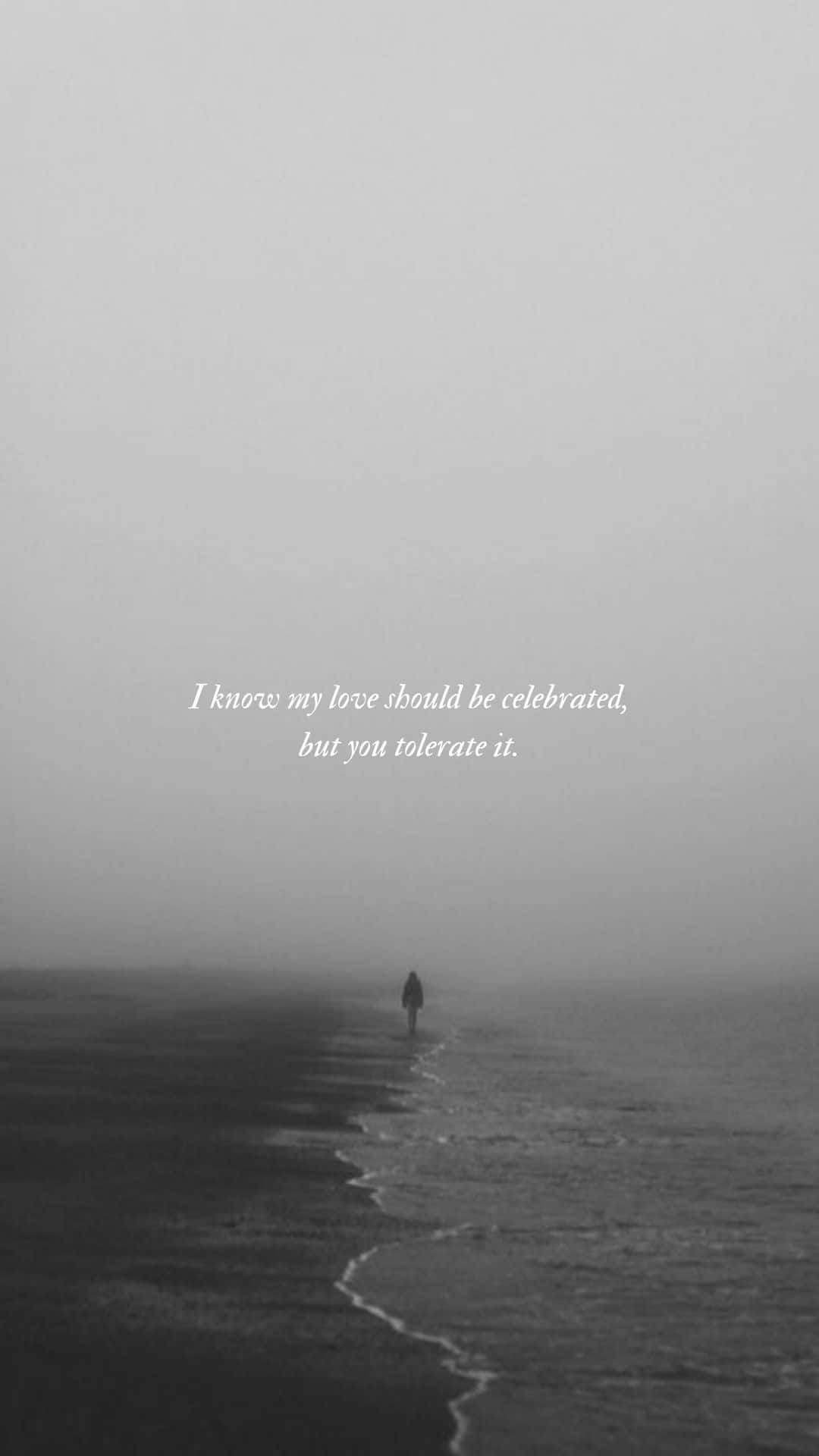 Taylor Swift Lyrics 桌布 壁紙 — 一個孤獨的身影沿著霧濛濛的海灘行走，海浪輕輕拍打岸邊，天空是暗淡的灰色。