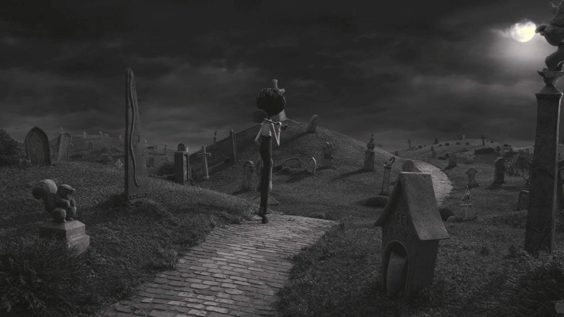 Frankenweenie 桌布 壁紙 — 一個孤獨的身影沿著鵝卵石小徑走過月光下的墓地，佈滿墓碑和詭異的雕像。