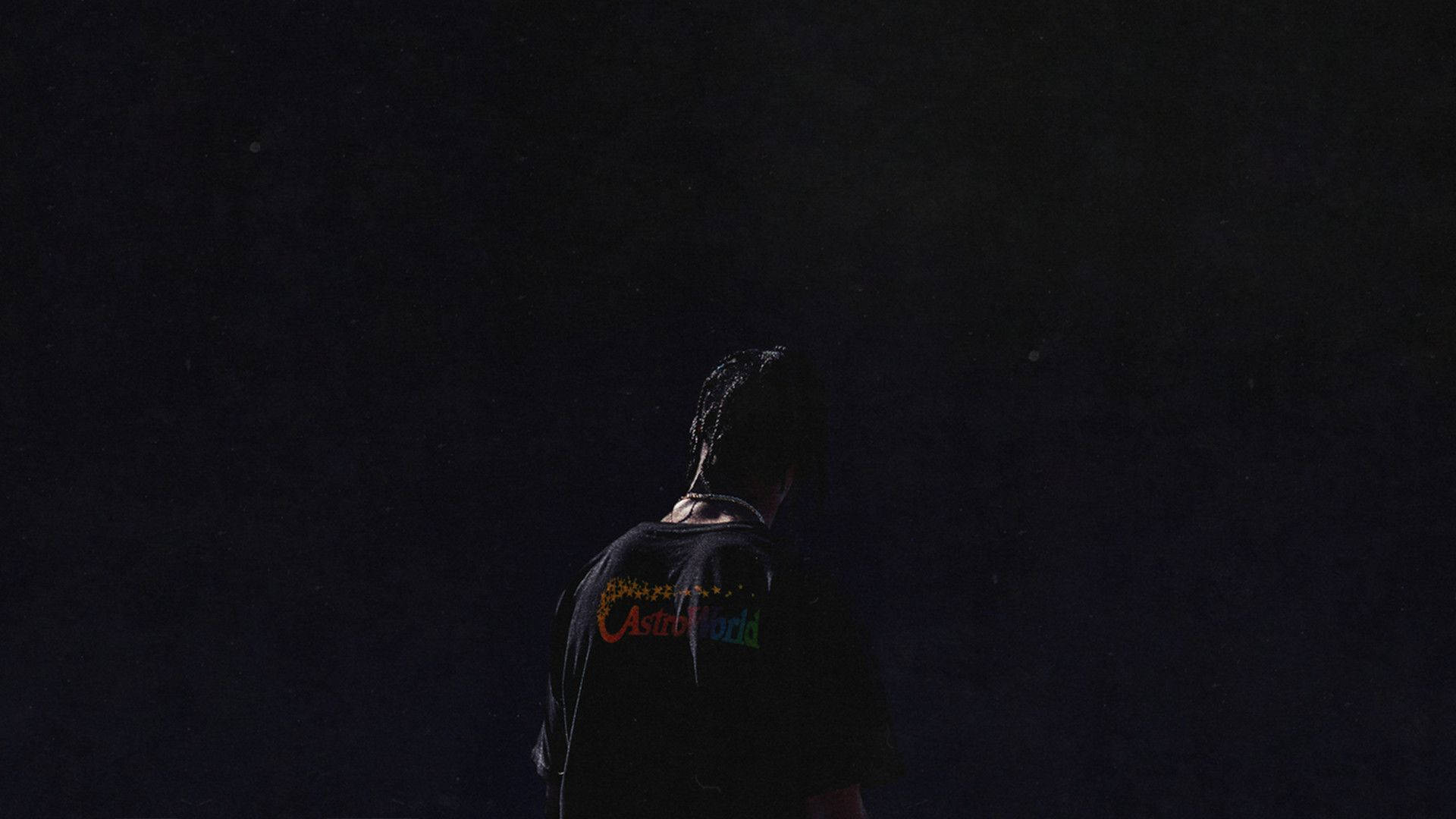 Astroworld 桌布 壁紙 — 一個孤獨的身影穿著帶有彩虹標誌的黑色T恤，在黑暗的星空夜空下形成剪影。