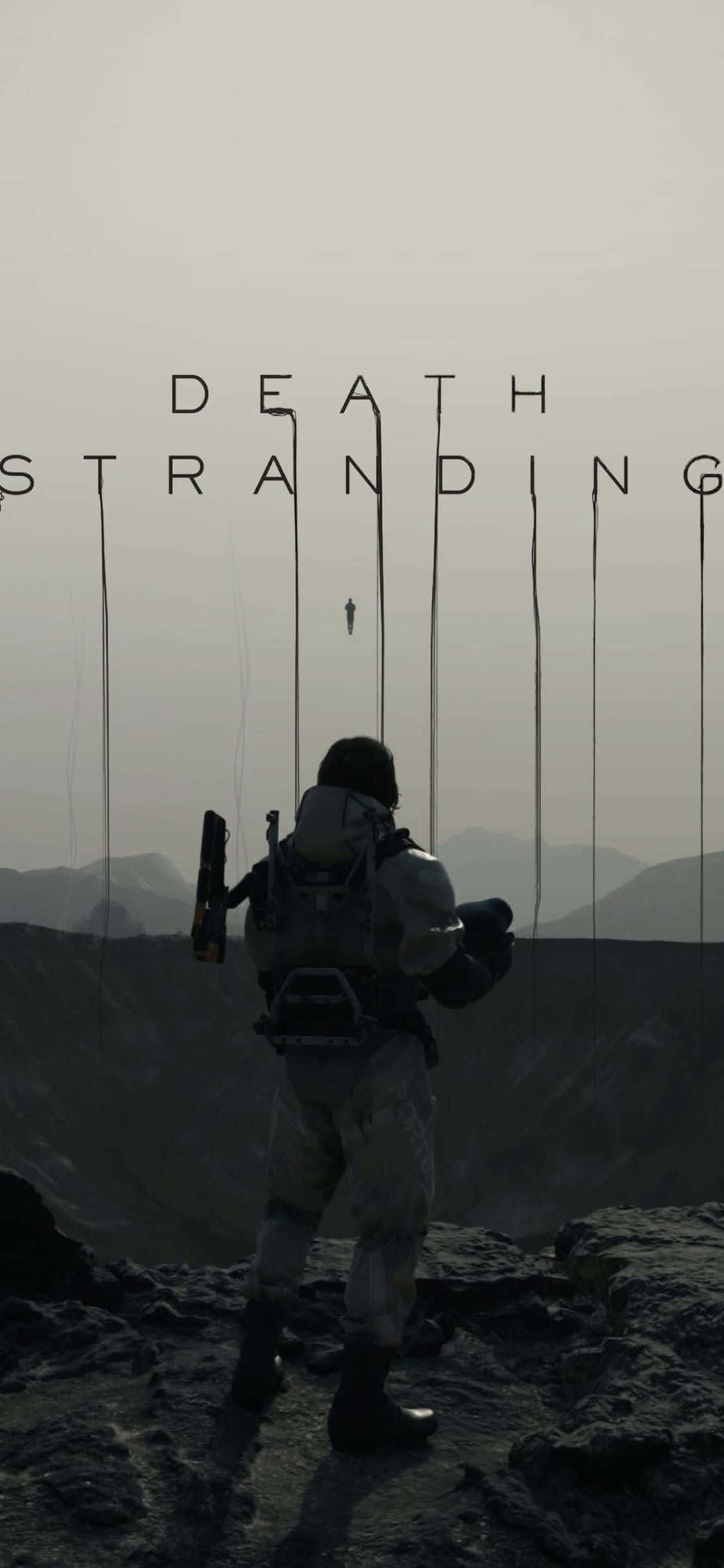iPhone X Death Stranding 桌布 壁紙 — 一個孤獨的身影穿著戰術裝備，站在岩石懸崖上，俯瞰著朦朧天空下荒涼的山脈，上方懸掛著「DEATH STRANDING」的標題。