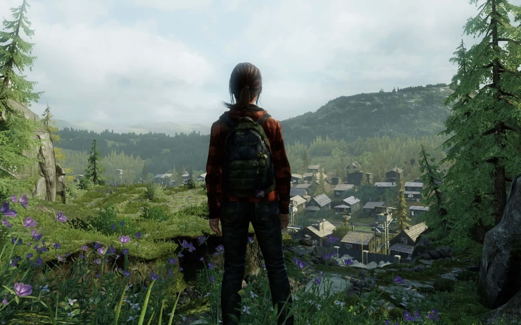 Survival Games 桌布 壁紙 — 一個孤獨的身影穿著紅色格紋衫，站在長滿苔蘚的懸崖上，俯瞰著一個坐落在連綿起伏的綠色山丘中的霧氣瀰漫的森林村莊。
