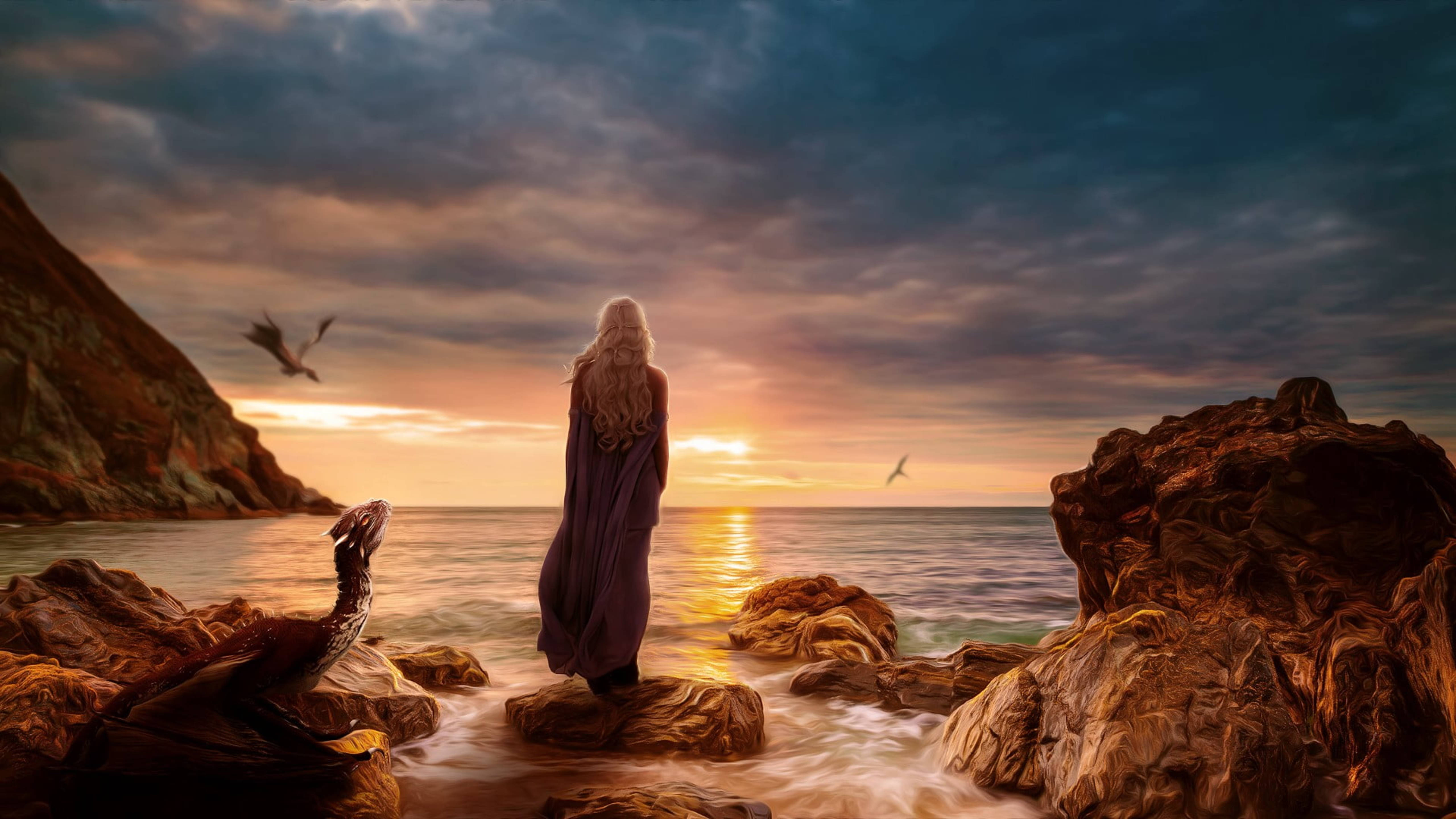 daenerys 桌布 壁紙 — 一個孤獨的身影穿著紫色長袍，站在日落時分的海岸岩石上，凝視著海洋，腳邊有一條龍，頭頂有鳥兒飛過。