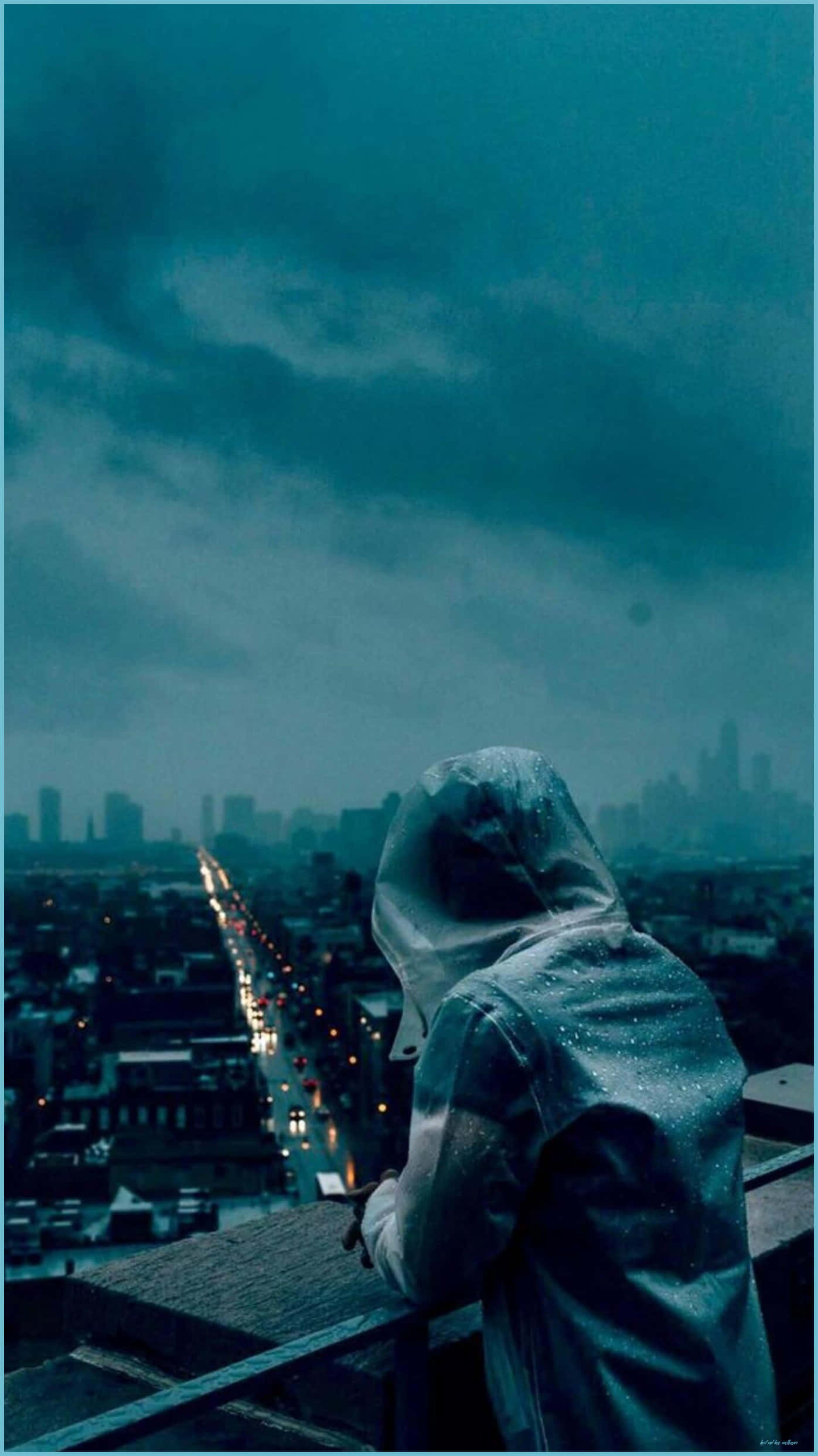 Depressed 桌布 壁紙 — 一個孤獨的身影穿著被雨水浸濕的連帽外套，在憂鬱的藍綠色天空下俯瞰城市景觀，遠處燈光閃爍。