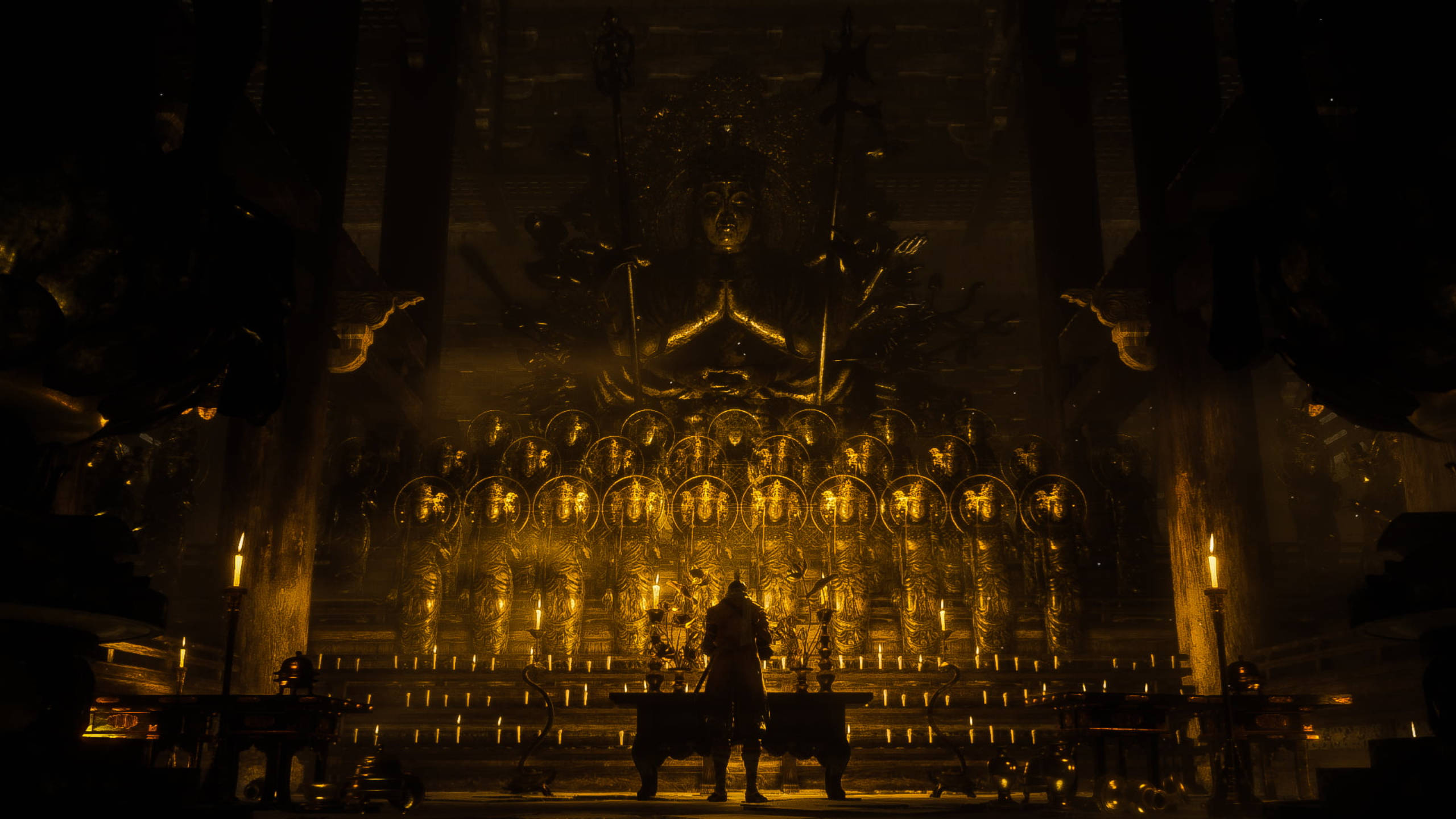 Sekiro 桌布 壁紙 — 一個孤獨的身影站在一座巨大的金色佛像前，周圍是成排較小的發光雕像，在一個燈光昏暗的寺廟中。