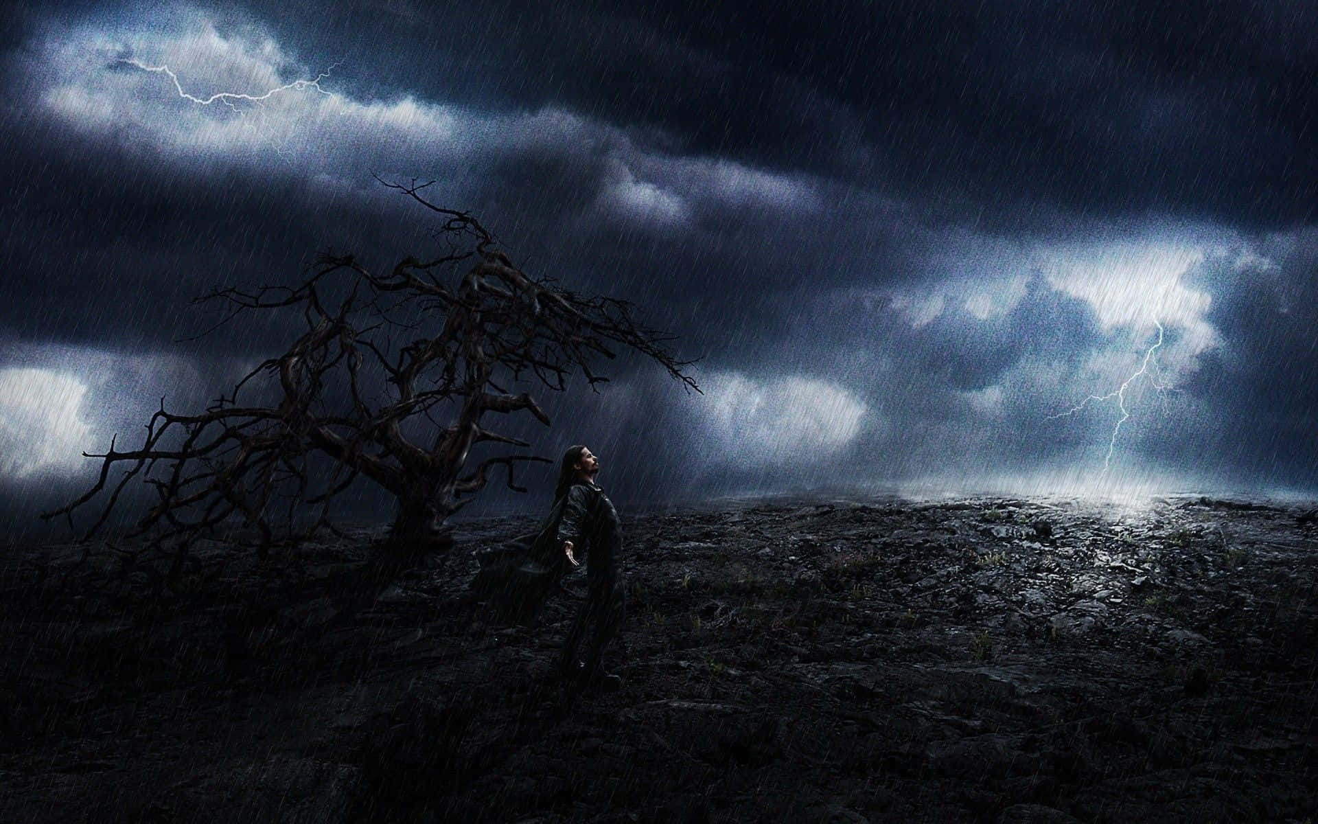 Thunderstorm 桌布 壁紙 — 一個孤獨的身影站在一棵枯樹下，閃電劃破暴風雨的天空，籠罩著荒涼的岩石平原。