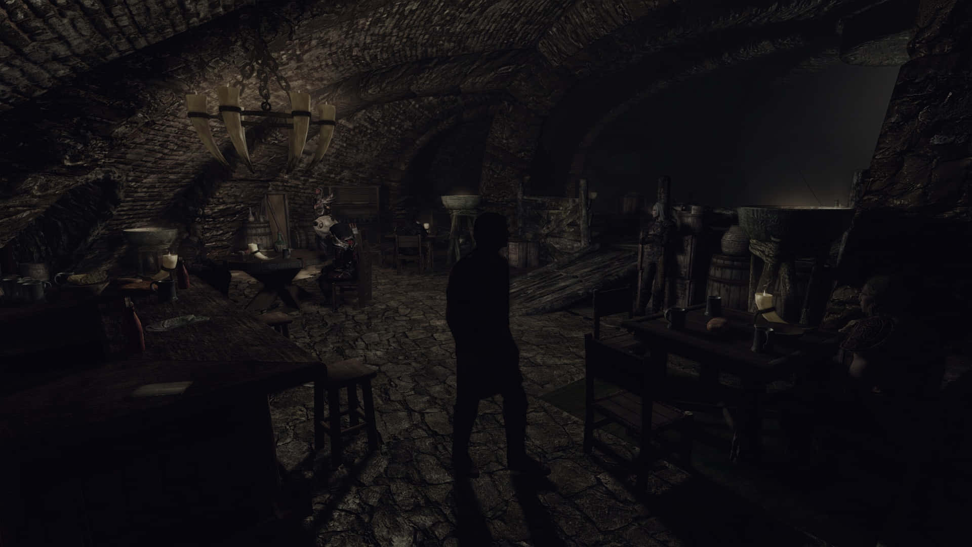 Thieves Guild 桌布 壁紙 — 一個孤獨的身影站在光線昏暗的石窖中，鵝卵石地板和懸掛的動物頭骨在搖曳的燭光下閃爍。