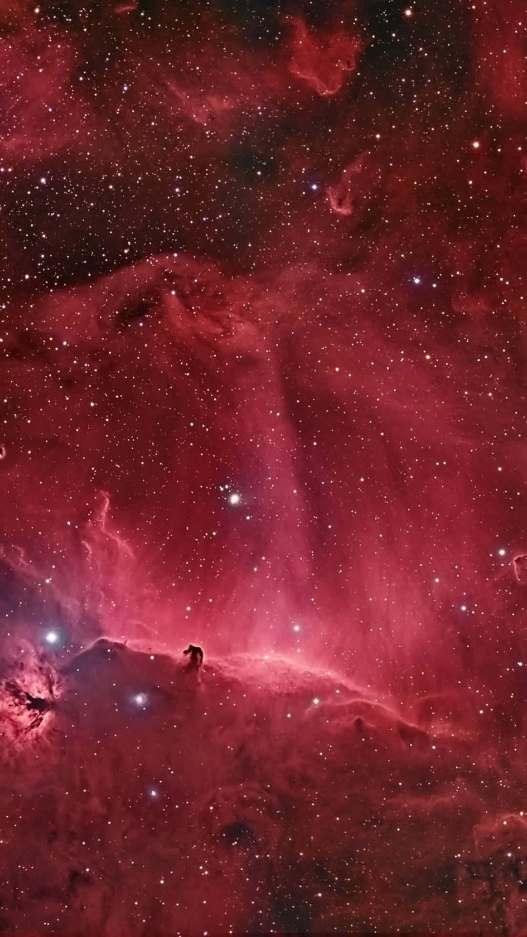 銀河 桌布 壁紙 — 一個孤獨的身影站在宇宙山脊上，下方是廣闊的紅色星雲，閃爍著無數星辰。