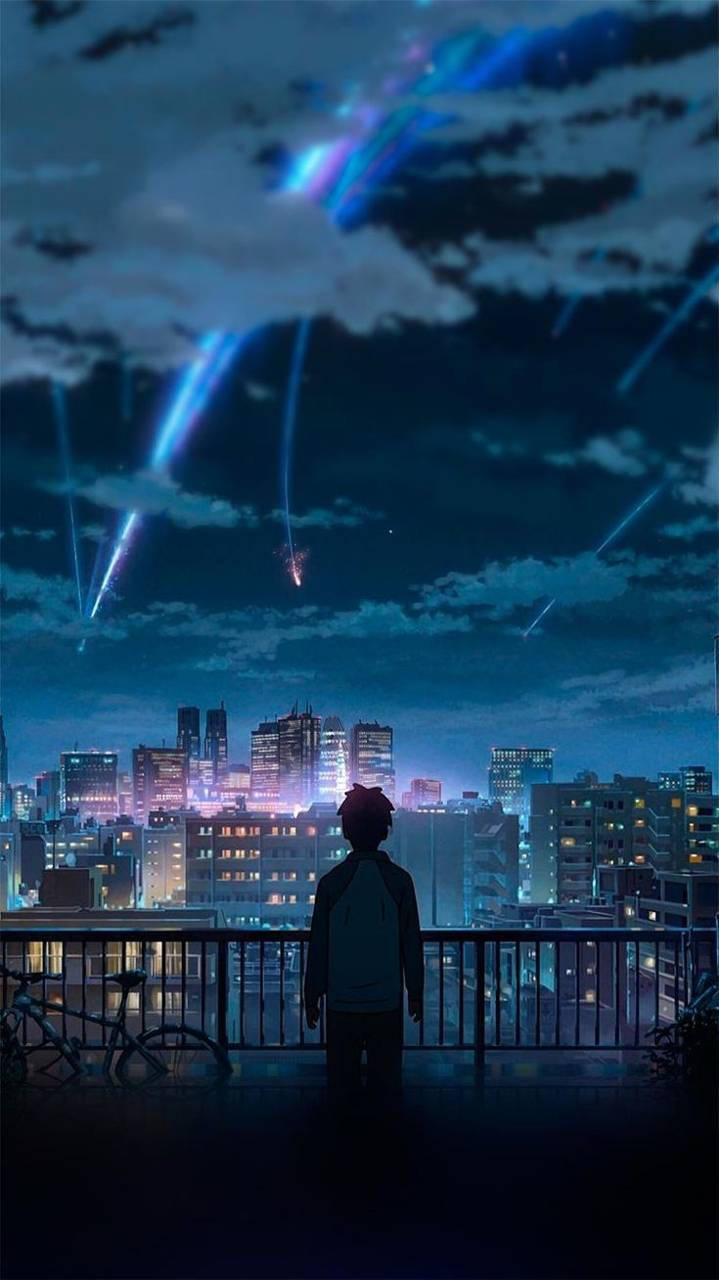 你的名字 桌布 壁紙 — 一個孤獨的身影站在屋頂陽台上，凝視著夜空中閃爍著藍色宇宙射線的充滿活力的城市景觀。