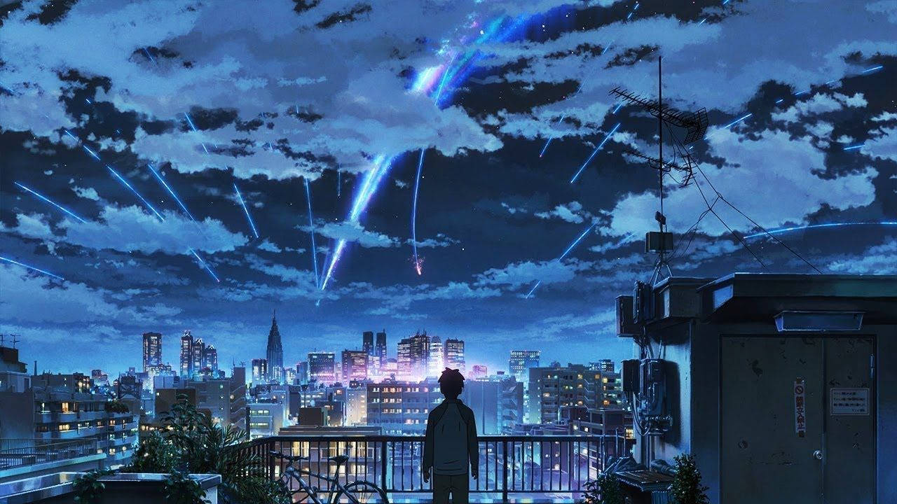 lofi 桌布 壁紙 — 一個孤獨的身影站在屋頂陽台上，凝視著下方充滿活力的城市景觀，藍色光線穿過多雲的夜空如雨般落下。