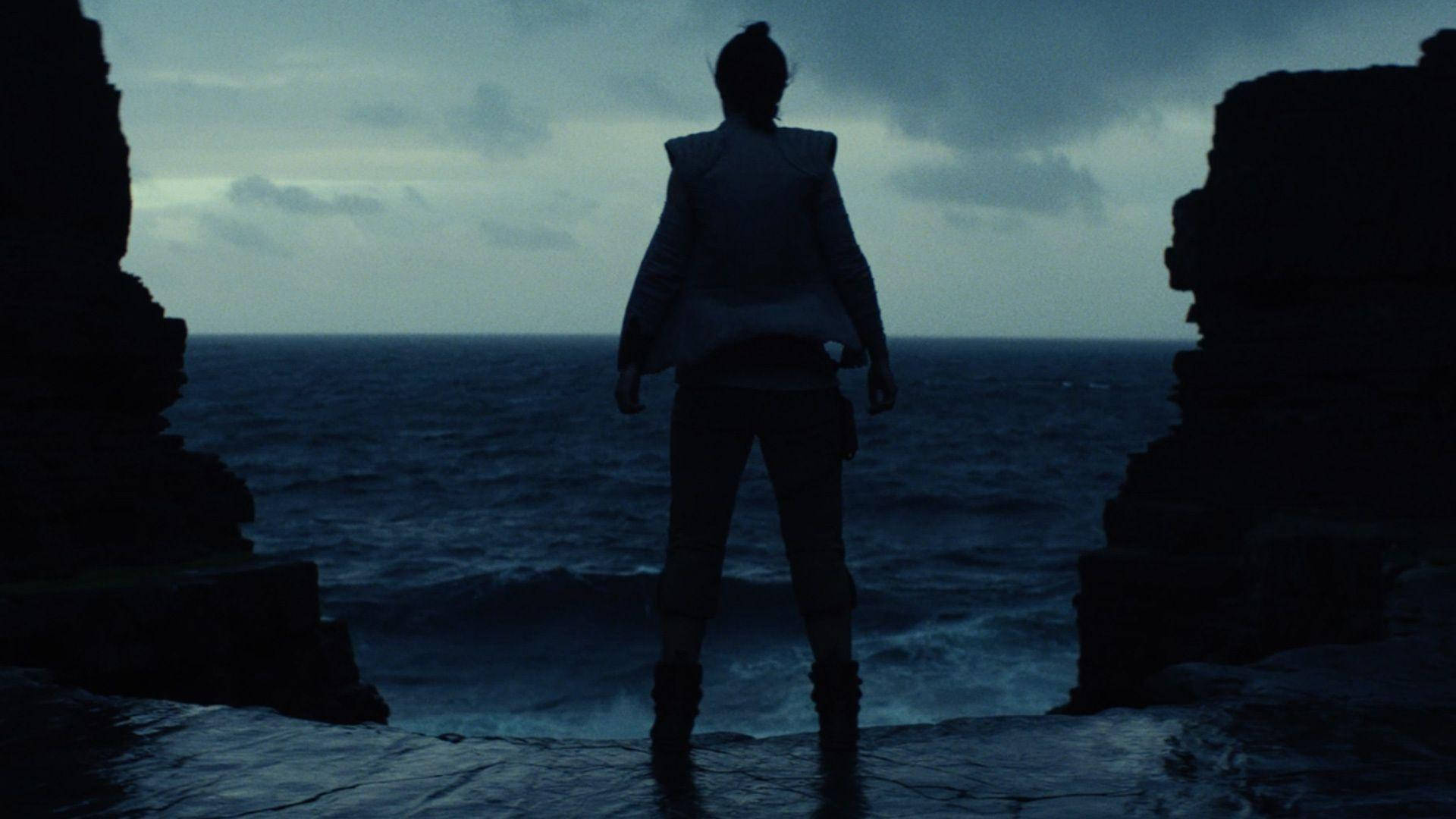 The Last Jedi Star Wars 桌布 壁紙 — 一個孤獨的身影站在岩石懸崖邊，面對著陰沉暮色下廣闊的黑暗海洋。