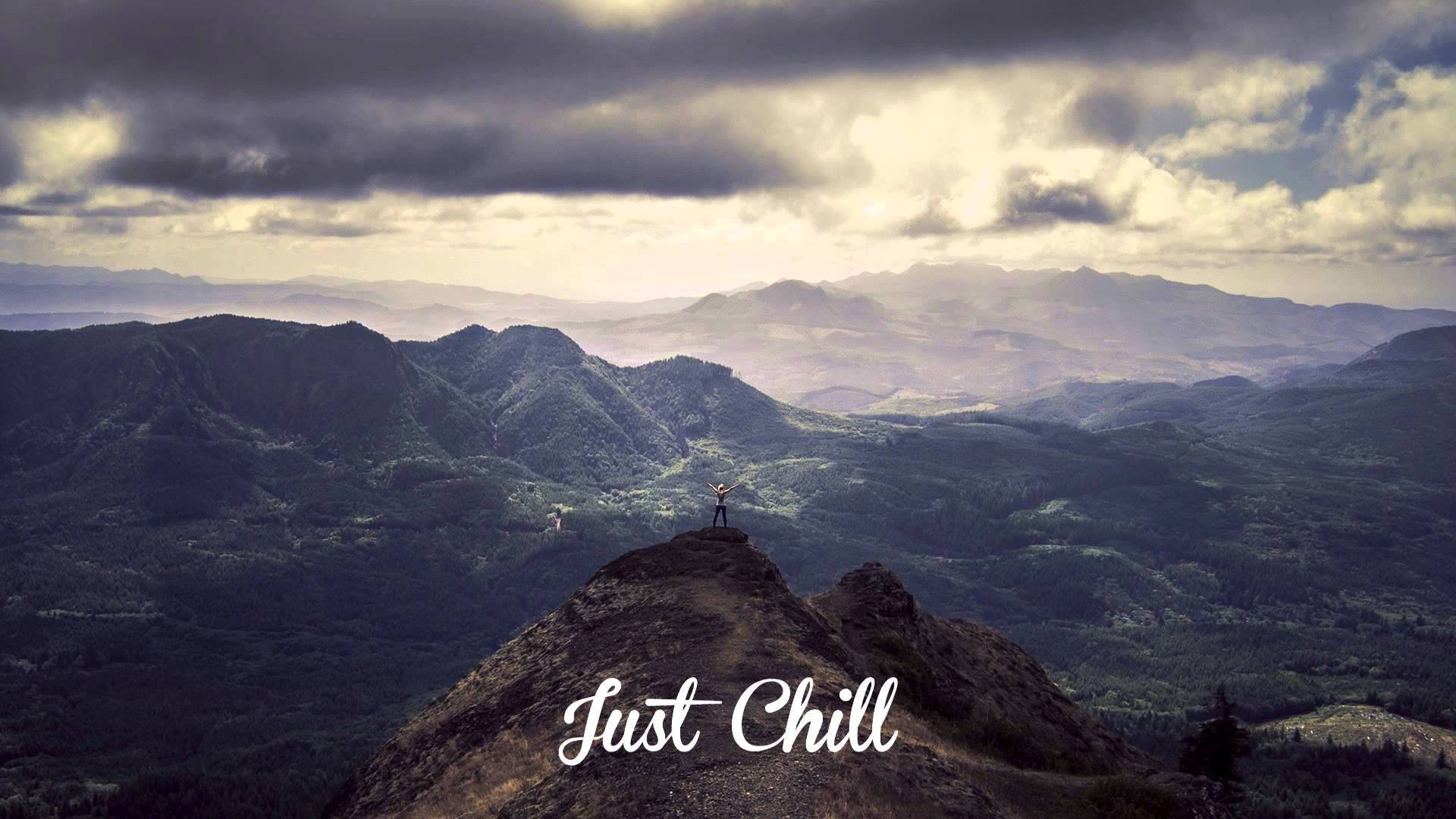 Chill 桌布 壁紙 — 一個孤獨的身影站在崎嶇的山頂上，俯瞰著在戲劇性的多雲天空下無盡起伏的丘陵。