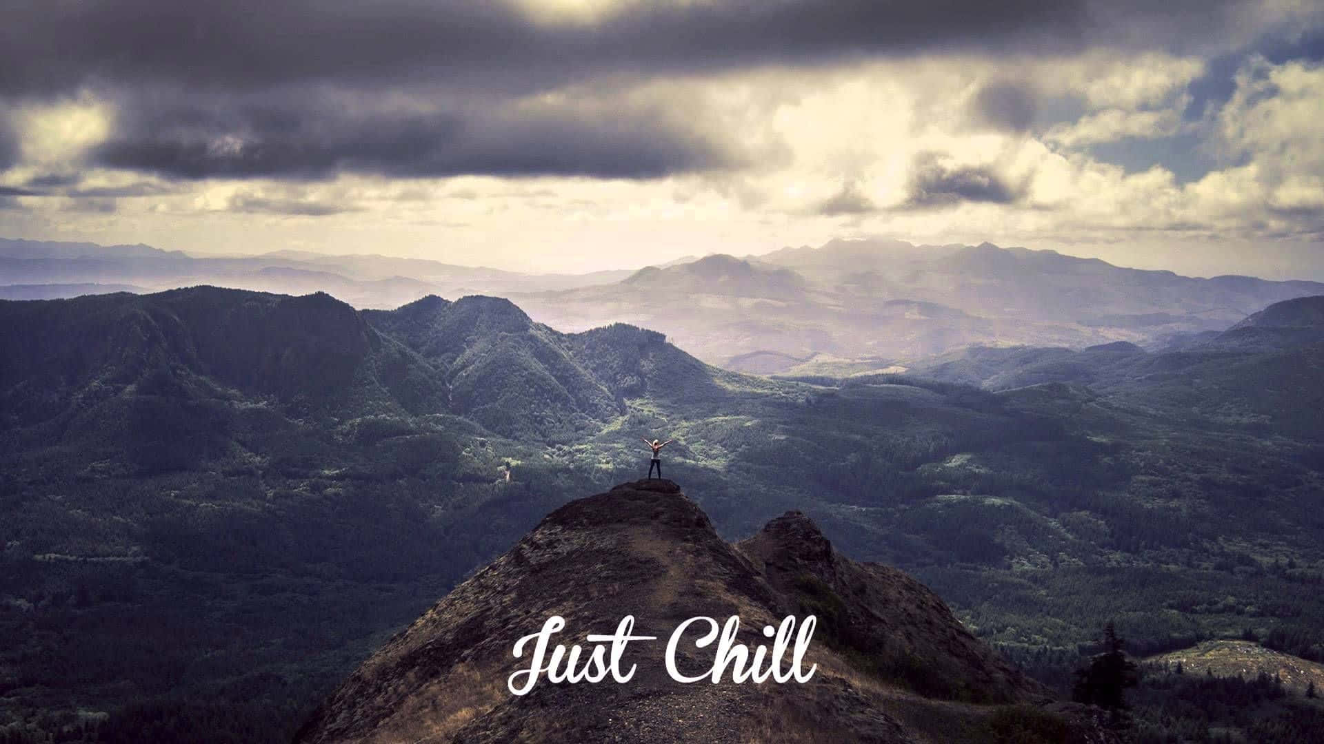 chill 桌布 壁紙 — 一個孤獨的身影站在崎嶇的山頂上，眺望著戲劇性多雲天空下無盡的連綿起伏山丘。