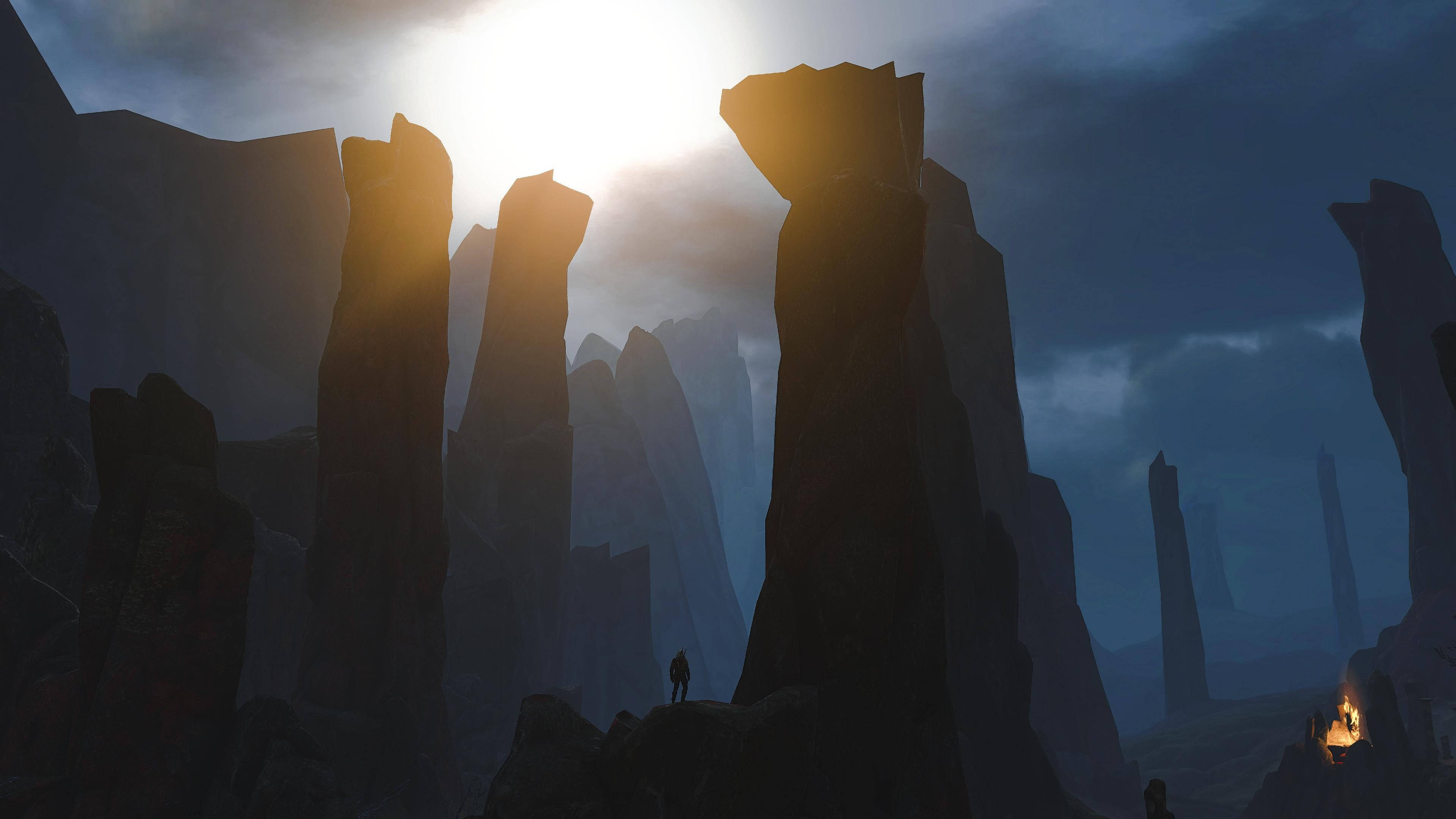 Witcher 桌布 壁紙 — 一個孤獨的身影站在崎嶇的岩石上，明亮的太陽穿過暴風雨的天空，灑下金色的光芒。
