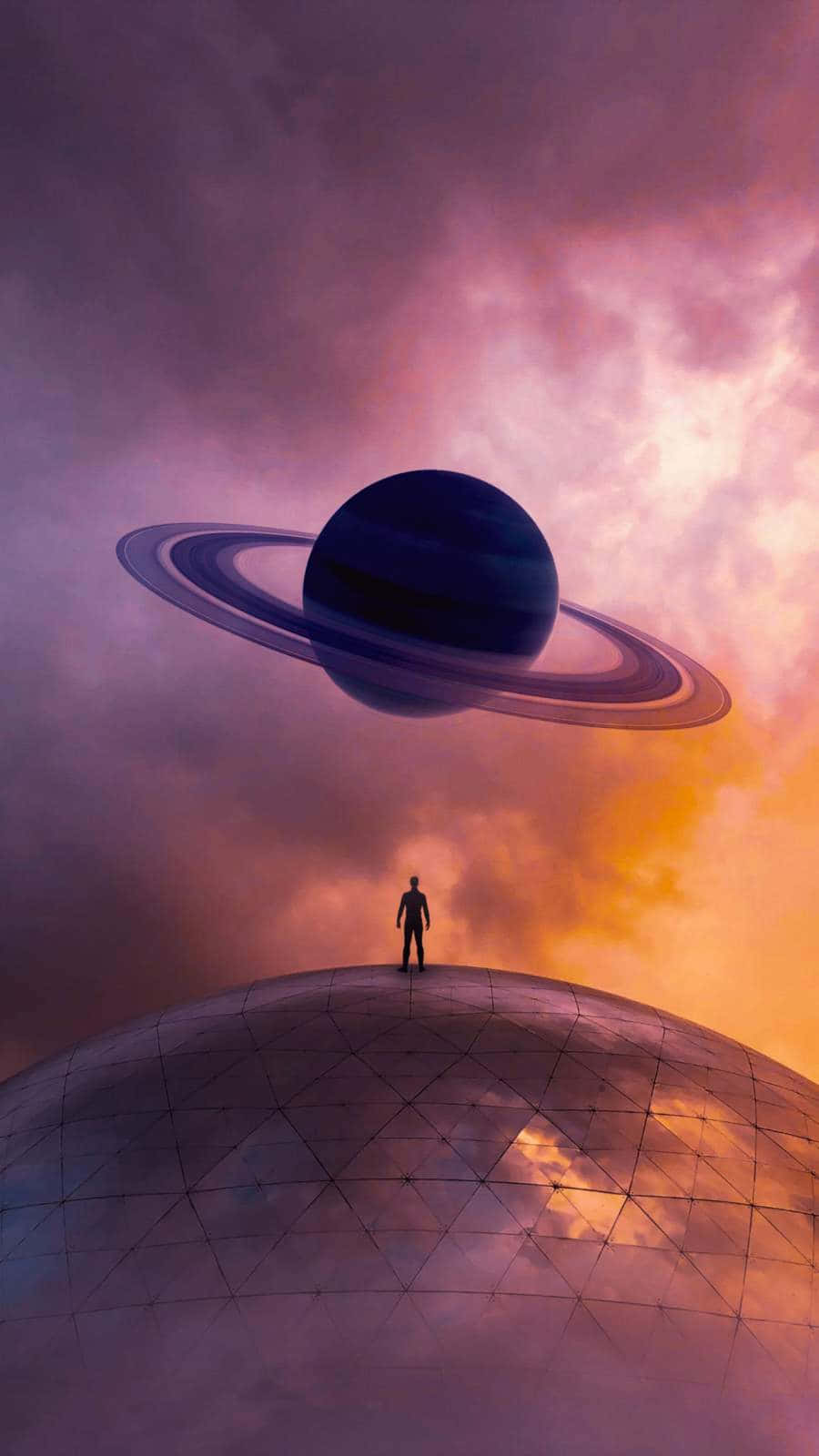土星 桌布 壁紙 — 一個孤獨的身影站在幾何圓頂上，仰望漂浮在充滿活力的暮色天空中的巨大環狀行星。
