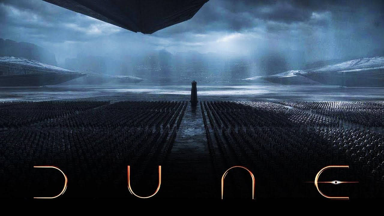 Dune Movie 桌布 壁紙 — 一個孤獨的身影站在廣闊的沙漠小徑上，下方是巨大的太空船，而暴風雲籠罩著遠山。