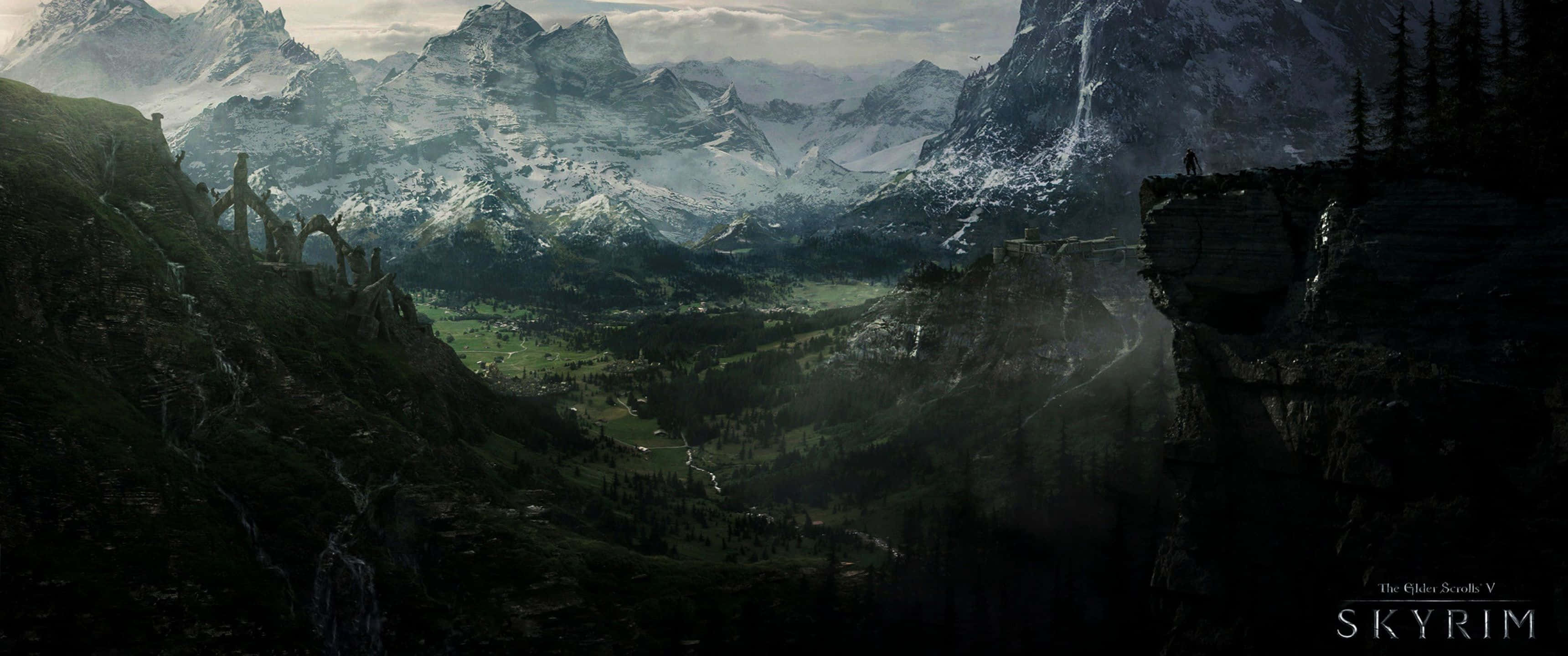 3440x1440p The Elder Scrolls V Skyrim 桌布 壁紙 — 一個孤獨的身影站在懸崖上，俯瞰著廣闊的山谷，山谷中有積雪的山峰和古老的廢墟。