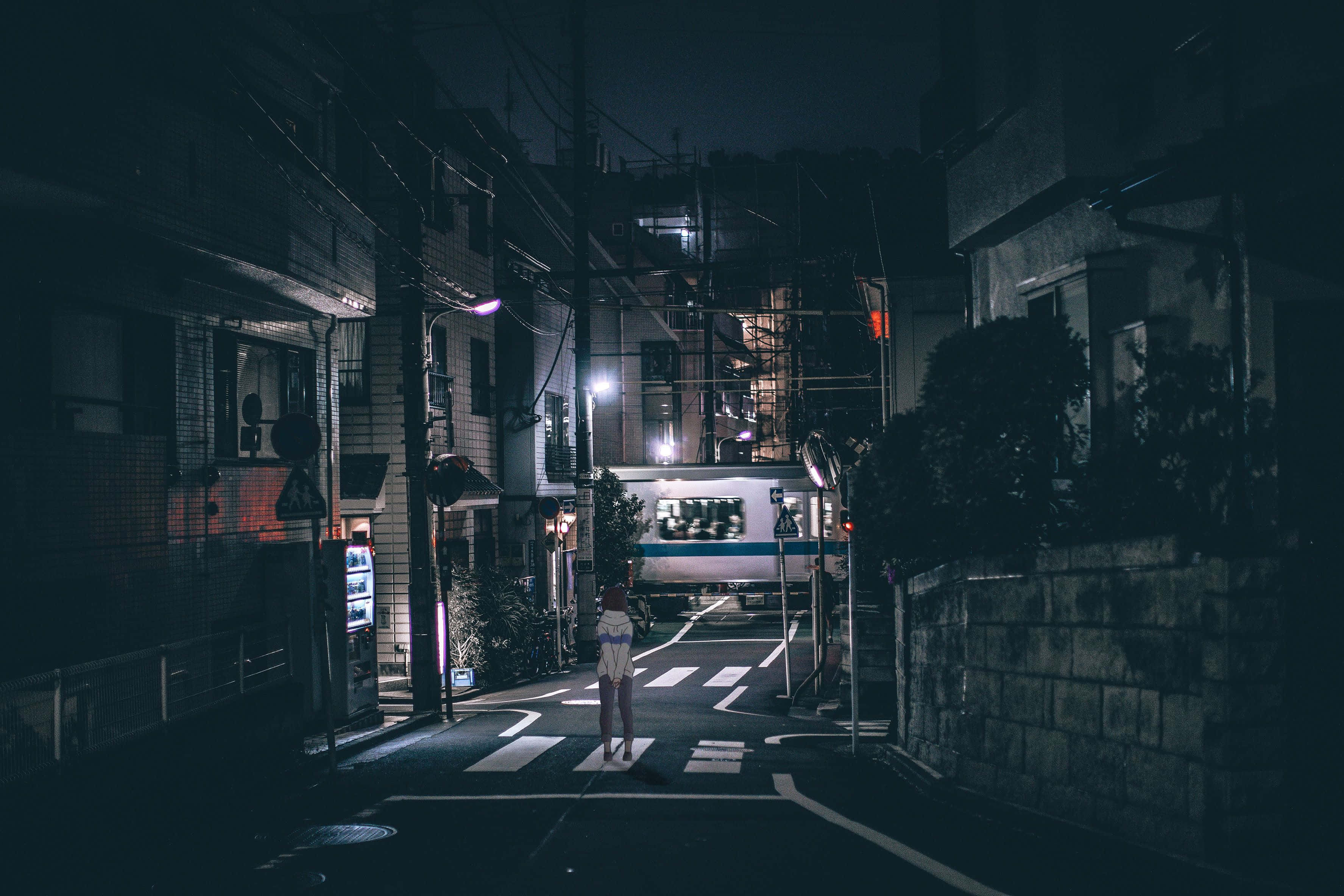 日式暗黑 桌布 壁紙 — 一個孤獨的身影站在昏暗的日本小巷中的行人穿越道，而火車在夜間駛過。