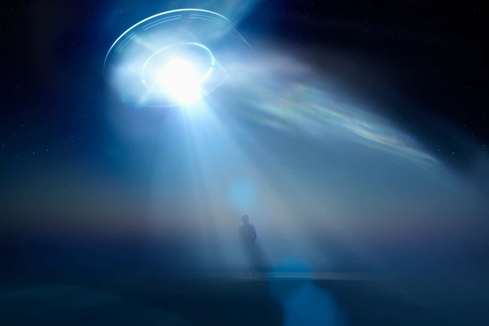 Blue Light Effects 桌布 壁紙 — 一個孤獨的身影站在發光的UFO下方，UFO在繁星點點的夜空中投射出耀眼的光束。