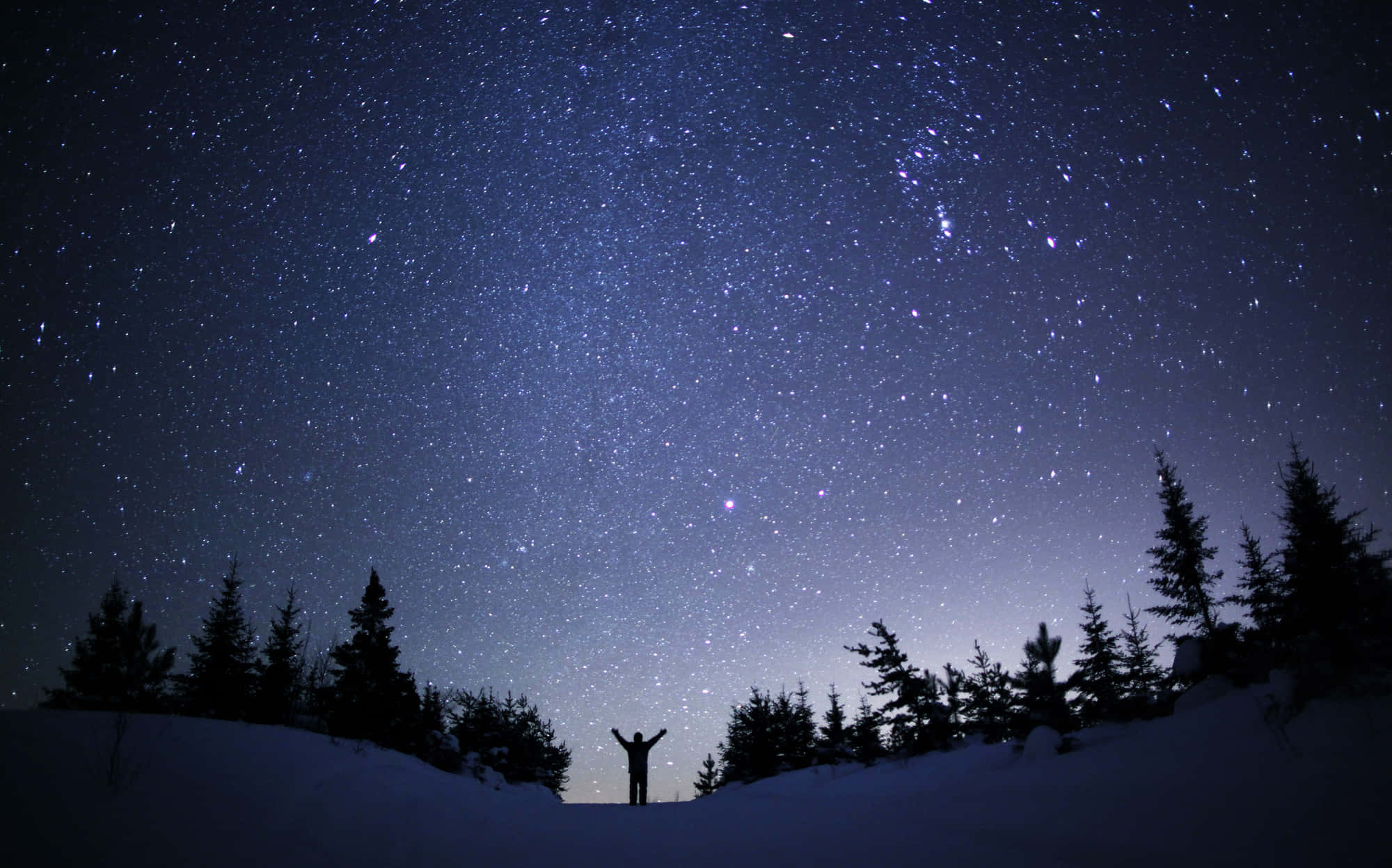 夜空 桌布 壁紙 — 一個孤獨的身影站在雪地荒野中，雙臂伸展，頭頂上是令人屏息的密集星空。