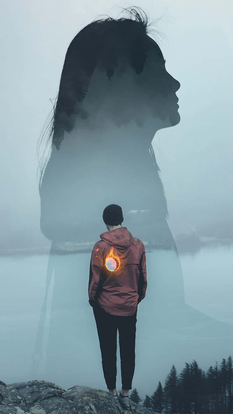 Woman 桌布 壁紙 — 一個孤獨的身影站在霧氣瀰漫的懸崖上俯瞰水面，他們的夾克上有一個幽靈般的女性輪廓和發光的太陽標誌。