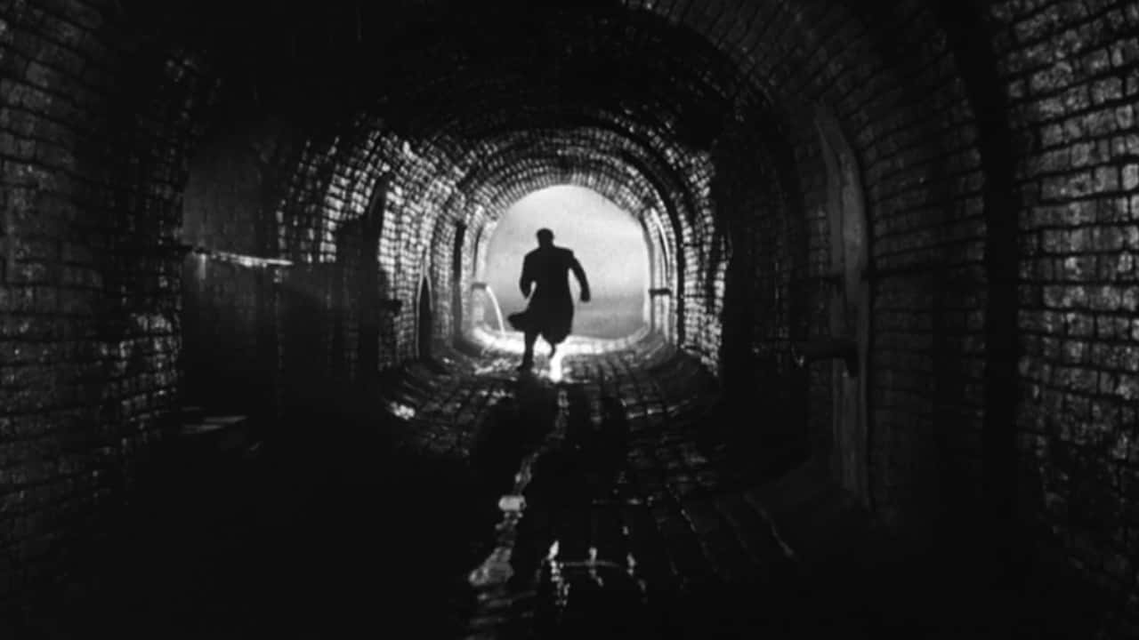 Film Noir 桌布 壁紙 — 一個孤獨的身影跑向黑暗潮濕磚砌隧道盡頭的光明。