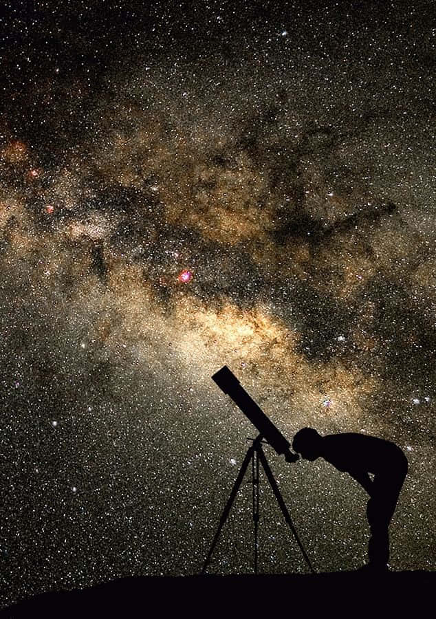 astronomy 桌布 壁紙 — 一個孤獨的身影透過望遠鏡凝視著銀河系發光的宇宙塵埃和星星。