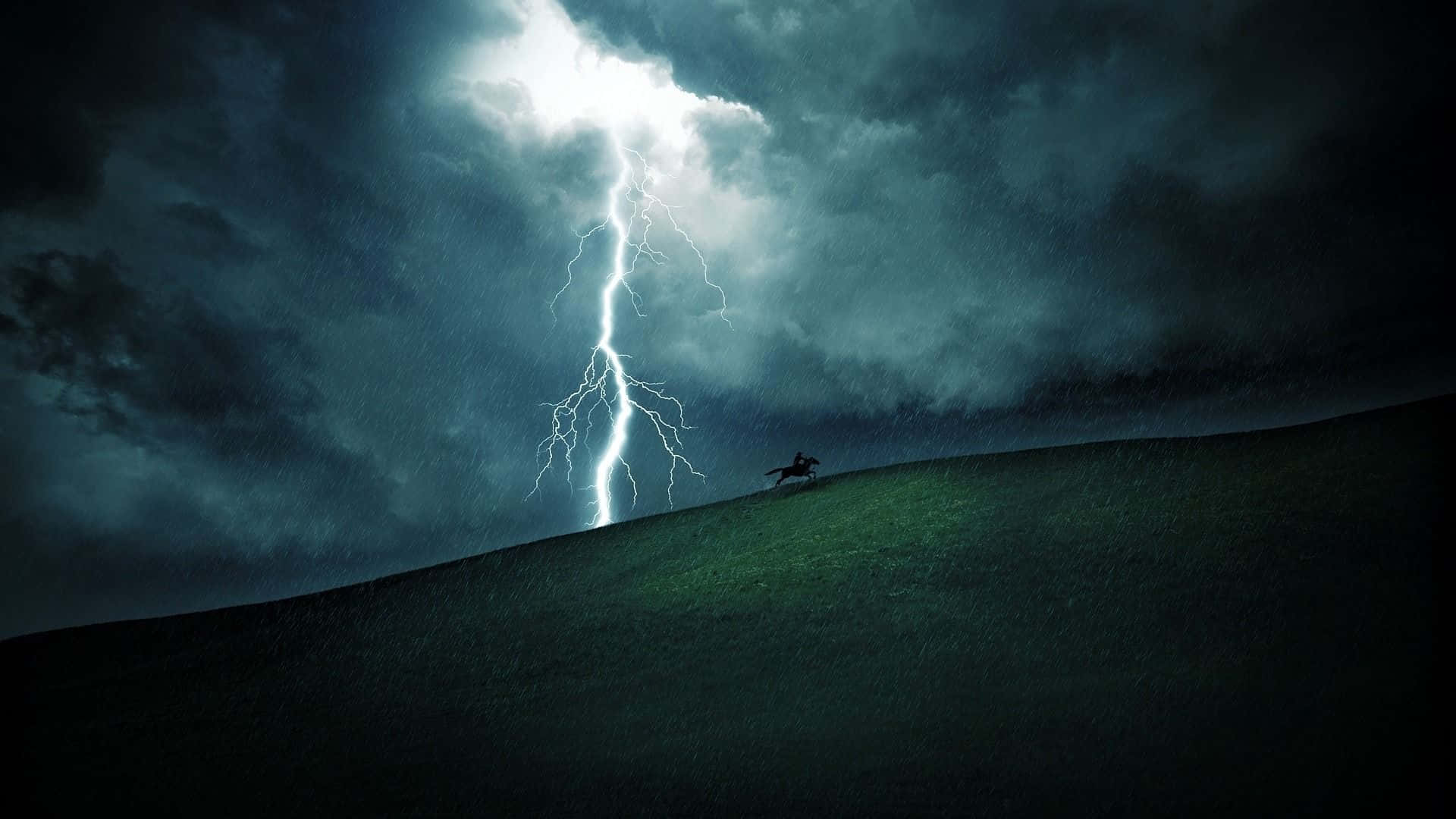 Thunderstorm 桌布 壁紙 — 一個孤獨的騎手騎在馬上，在戲劇性的山坡上形成剪影，一道巨大的閃電擊中上方暴風雨的天空。