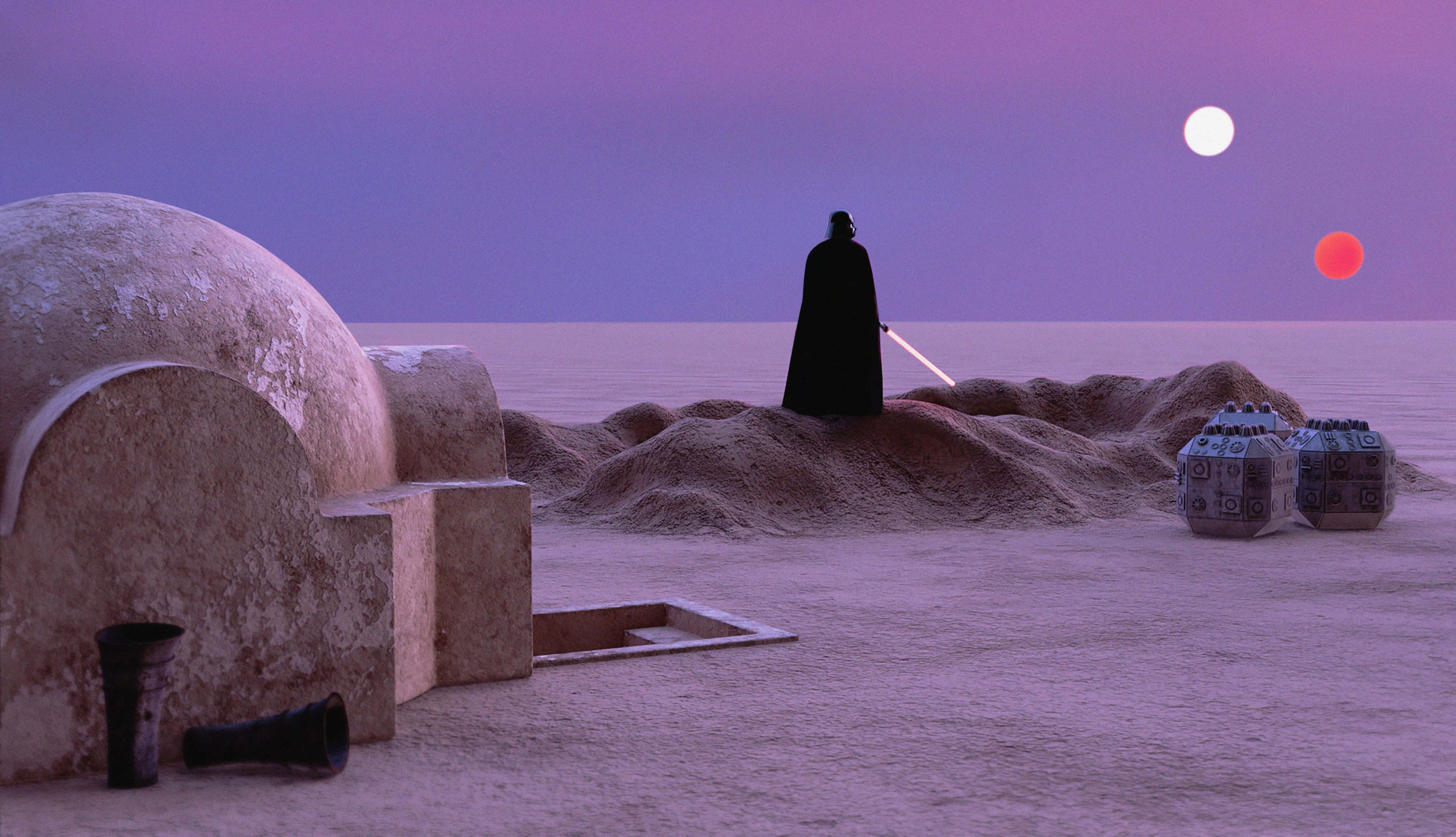 Tatooine 桌布 壁紙 — 一個孤獨的黑暗身影站在沙漠沙丘上，在暮色天空下有兩個月亮，手持發光的激光劍。
