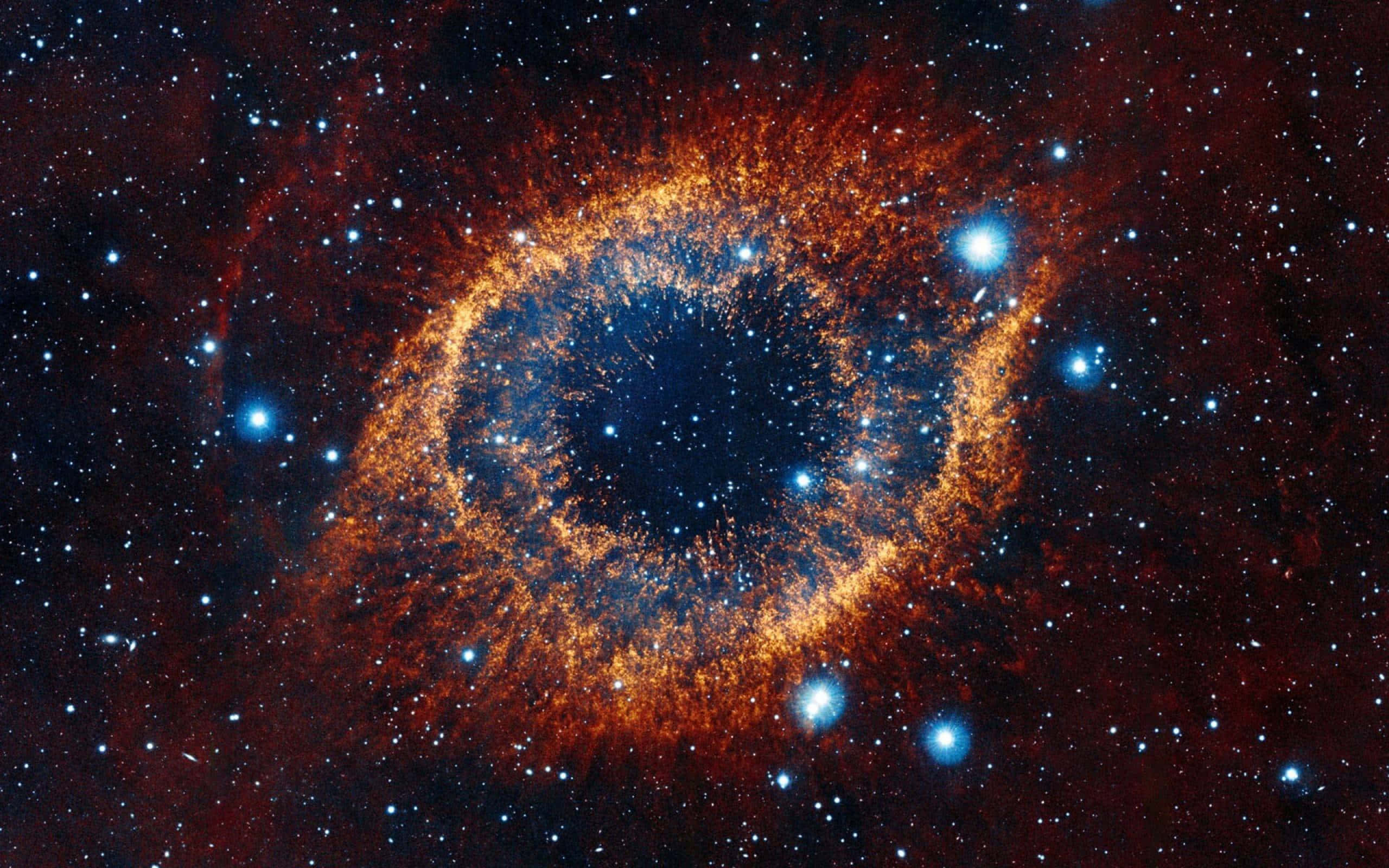 銀河 桌布 壁紙 — 一個宇宙星雲，帶有火熱的橙色卷鬚，圍繞著一個深藍色的中心旋轉，中心點綴著明亮的藍色星星，背景是星場。