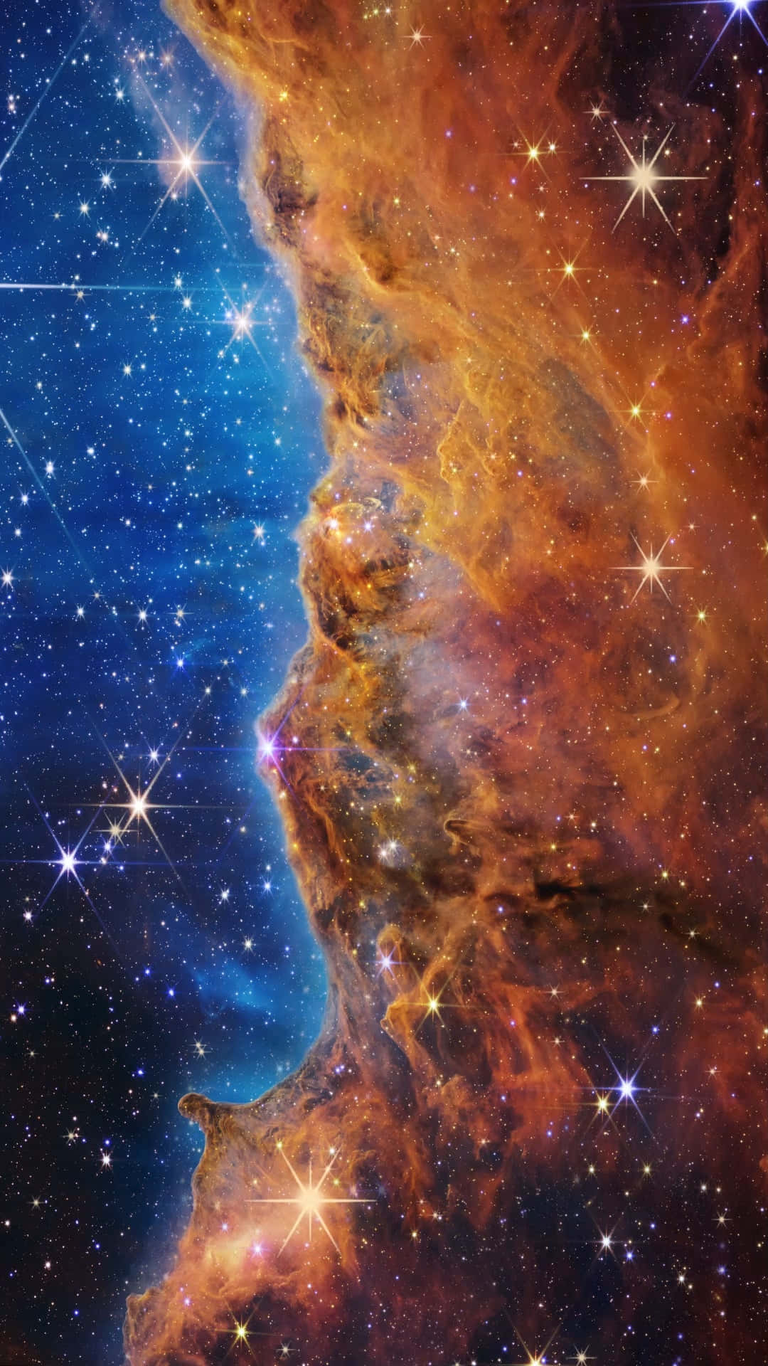 星雲 桌布 壁紙 — 一個宇宙星雲，帶有火熱的橙色雲朵和閃爍的星星，襯托在深藍色的虛空中。
