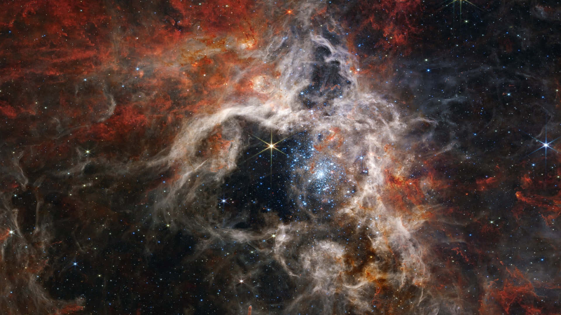 Cosmic 桌布 壁紙 — 一個宇宙星雲在佈滿星星的黑色虛空中旋轉，呈現火紅和發光的白色。