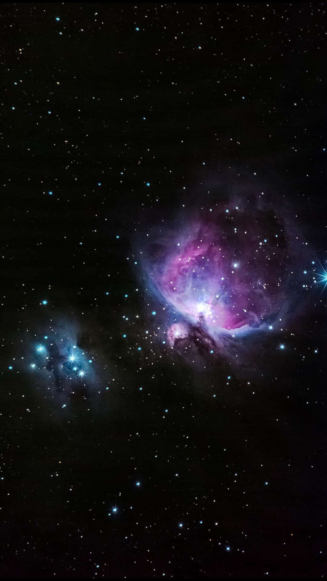Orion 桌布 壁紙 — 一個宇宙星雲在佈滿星星的黑色虛空中散發出充滿活力的紫色和藍色色調。