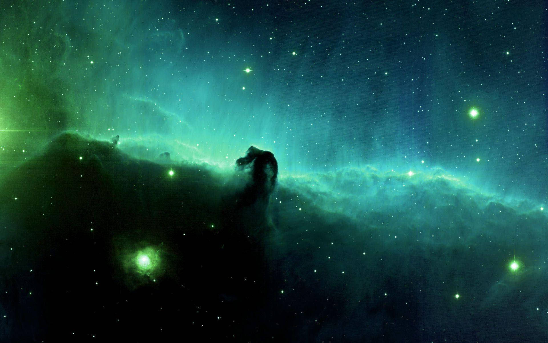 銀河 桌布 壁紙 — 一個宇宙星雲在星場背景下散發出充滿活力的綠色和藍綠色調，並呈現出一個黑暗的宇宙柱狀輪廓。