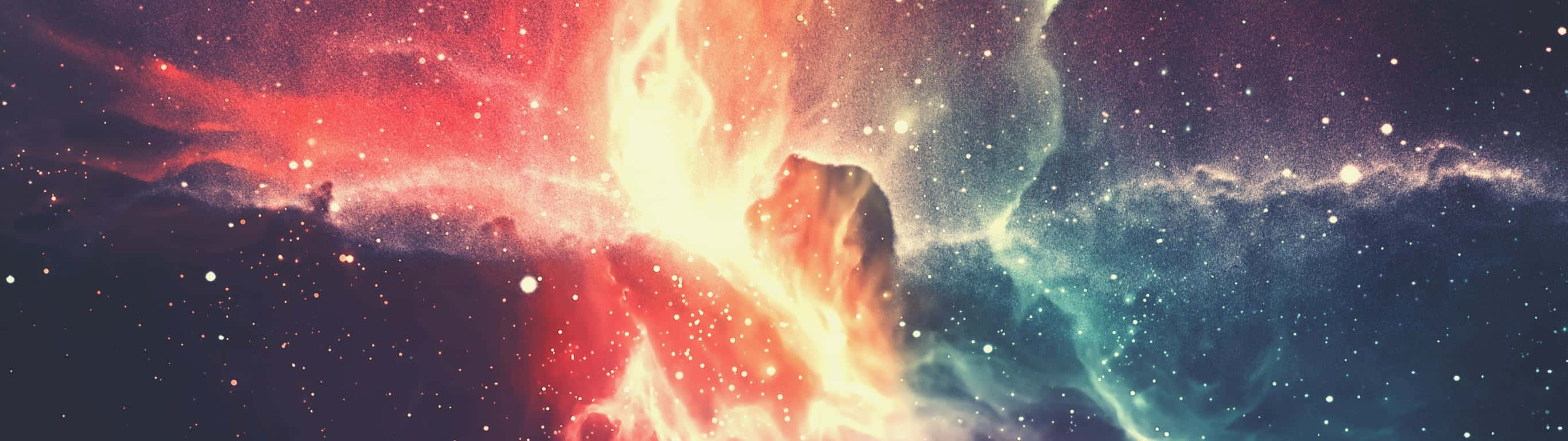 桌布 壁紙 — 一個宇宙星雲在星空中爆發，呈現熾熱的紅色和冷藍色，散發著天體能量。