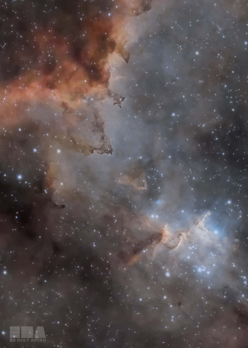 銀河 桌布 壁紙 — 一個宇宙星雲在星空背景下旋轉，散發著橙色和藍色的發光氣體雲。