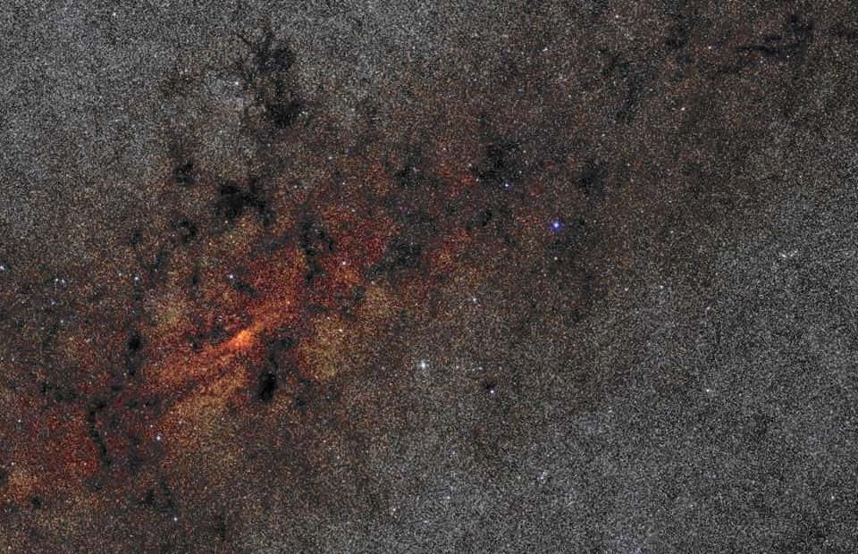Galactic Center 桌布 壁紙 — 一個宇宙星雲在星空背景下發出火橙色和深黑色的光芒。