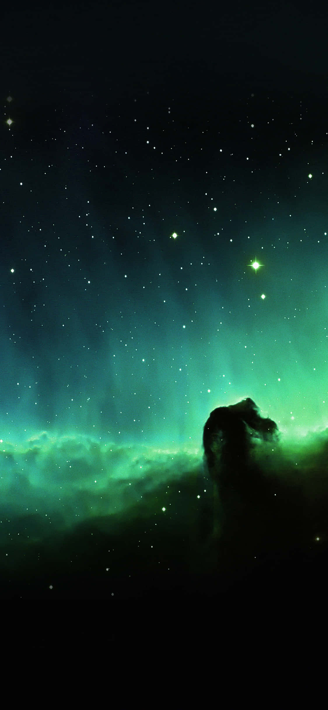 Beautiful Space 桌布 壁紙 — 一個宇宙星雲在繁星點點的夜空下發出鮮豔的綠光，下方有一個黑暗的天體輪廓。