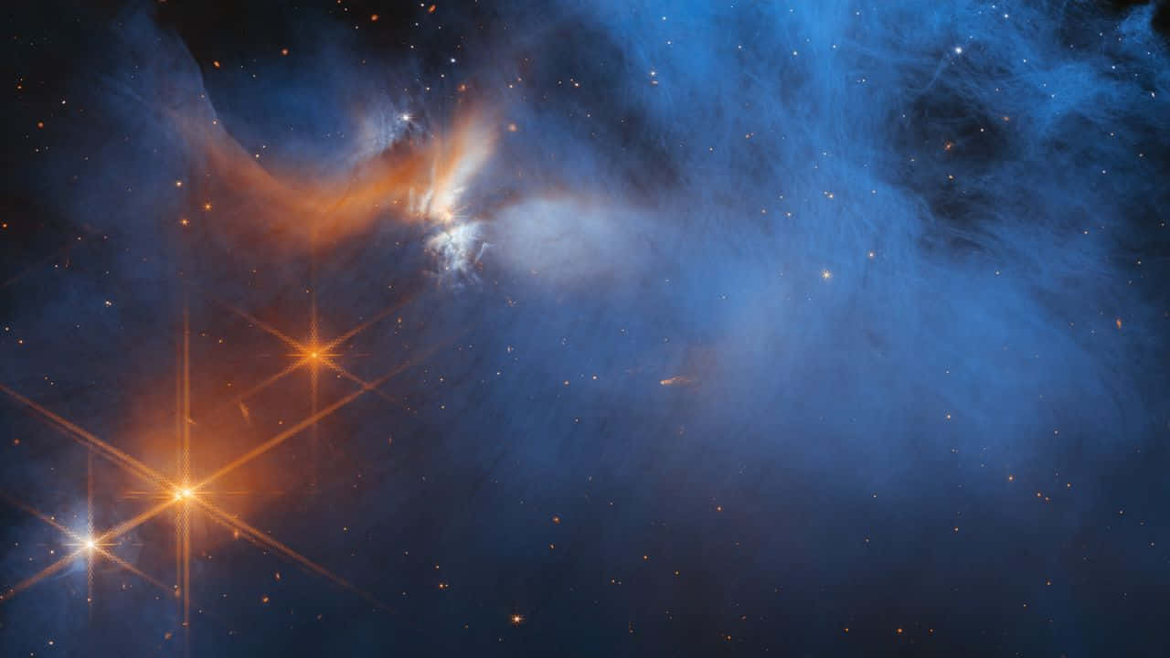 Outerspace 桌布 壁紙 — 一個宇宙星雲在黑暗虛空中旋轉，充滿活力的藍色和火熱橙色氣體雲被燦爛的星星照亮。