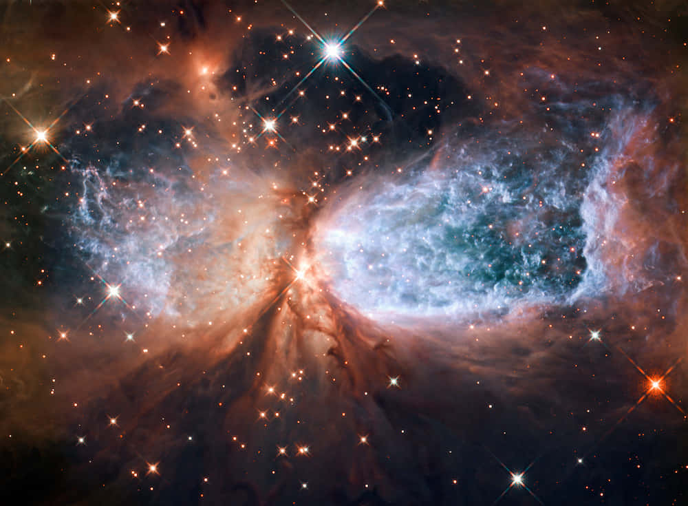 Stars 桌布 壁紙 — 一個宇宙星雲在黑暗虛空中旋轉，散發著藍色和橙色的發光氣體，被燦爛的星星照亮。