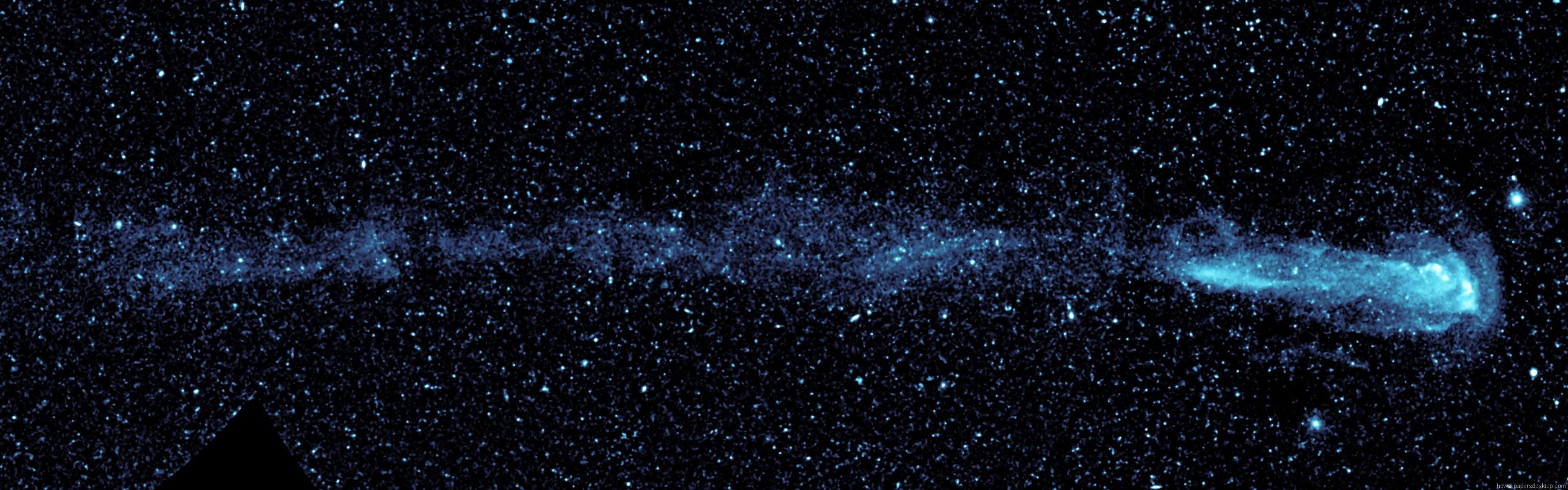 桌布 壁紙 — 一個宇宙景觀，展示了一個發光的藍色星雲橫跨星場，底部有一個深色三角形剪影。