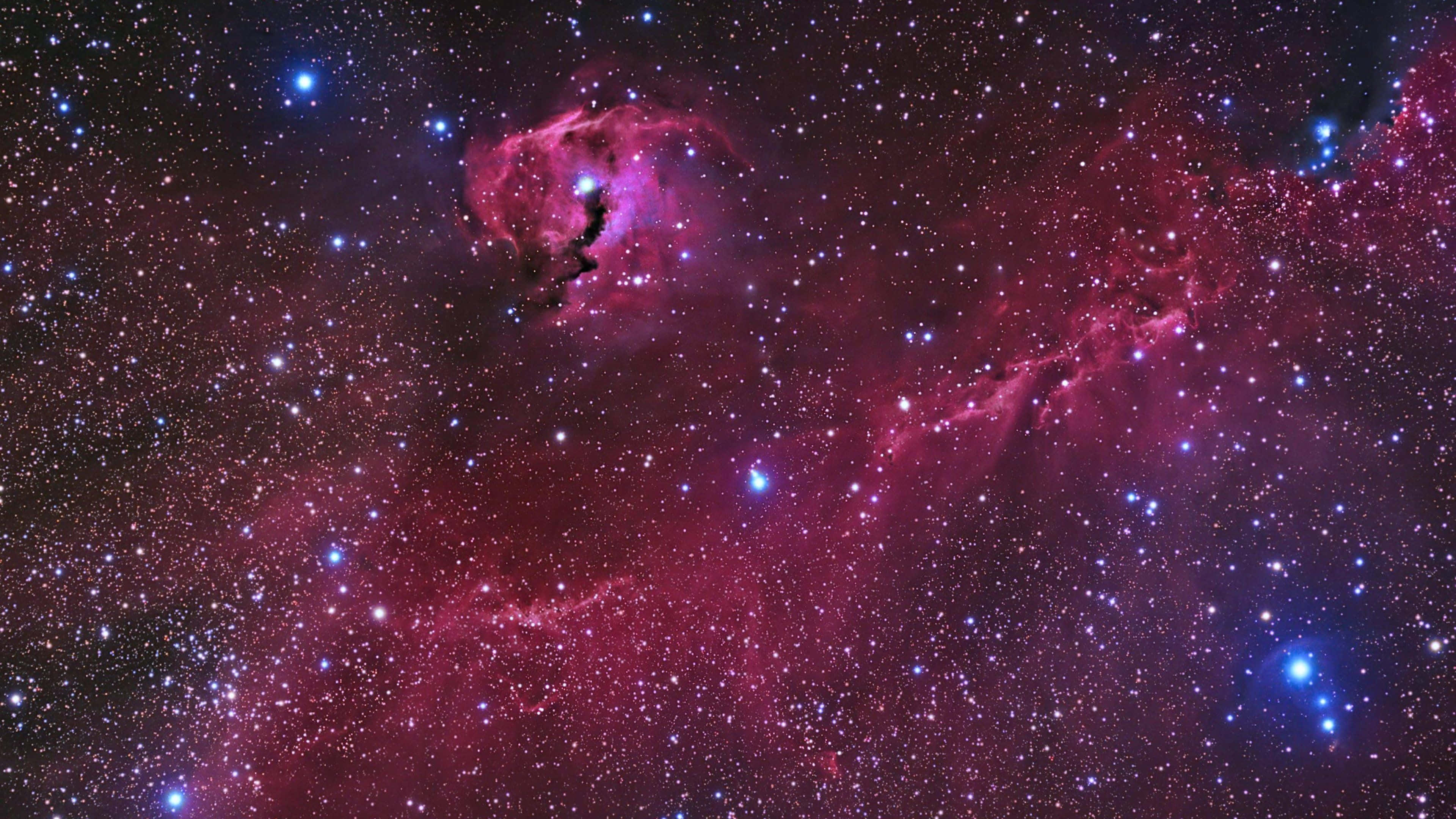 夜空 桌布 壁紙 — 一個宇宙景觀，發光的粉紅色和紫色星雲點綴著明亮的藍色星星，背景是深邃的黑色虛空。