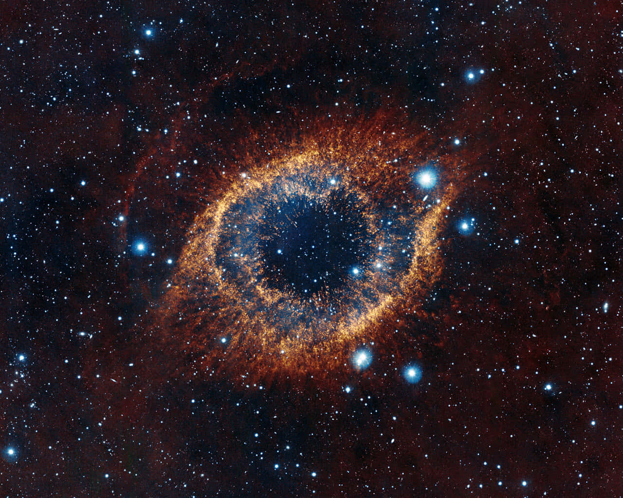 銀河 桌布 壁紙 — 一個宇宙眼睛星雲，在廣闊黑暗的太空中，被無數恆星包圍，散發出火熱的橙色和深藍色色調。
