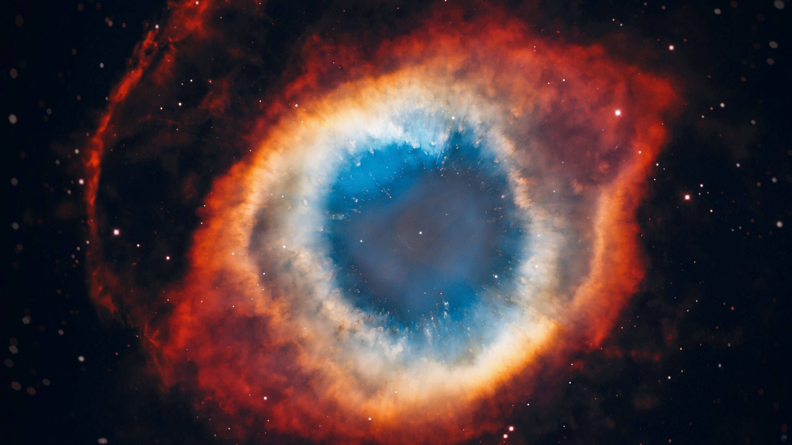 NASA 動態圖片 桌布 壁紙 — 一個宇宙眼睛星雲，在繁星點點的黑色虛空中散發著火橙色和深藍色的光環。