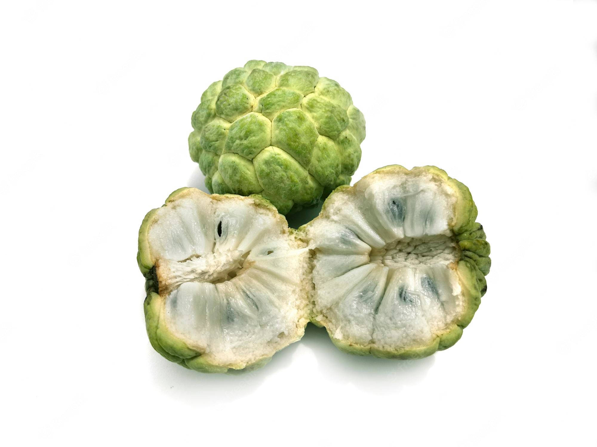 Fruits 桌布 壁紙 — 一個完整和切半的綠色刺果番荔枝果實，在純白色背景上露出其奶油狀的白色果肉和深色種子。
