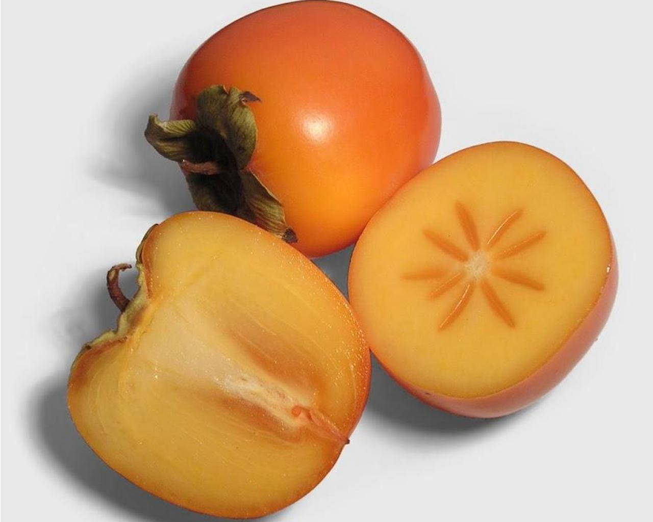 Fruit 桌布 壁紙 — 一個完整和半切的柿子，在純白背景上顯露出星形的種子腔。