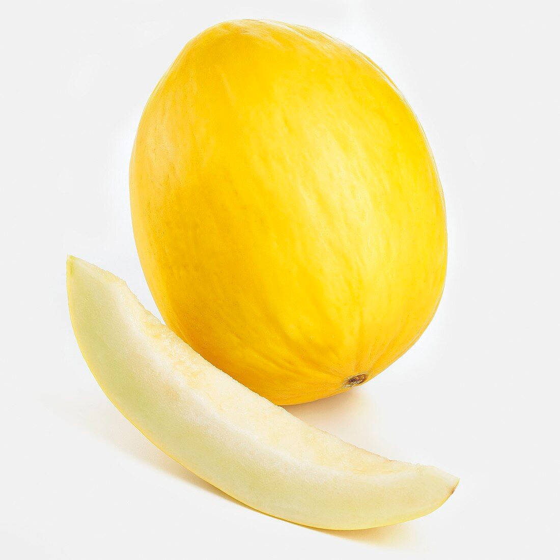 Fruit 桌布 壁紙 — 一個完整的黃色哈密瓜，旁邊放著一片淡色的切片，背景是潔淨的白色。
