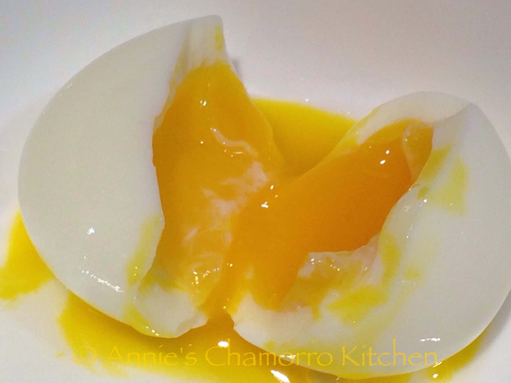 Egg White 桌布 壁紙 — 一個完美半熟蛋切開，露出流心金黃蛋黃，滲到白色盤子上。