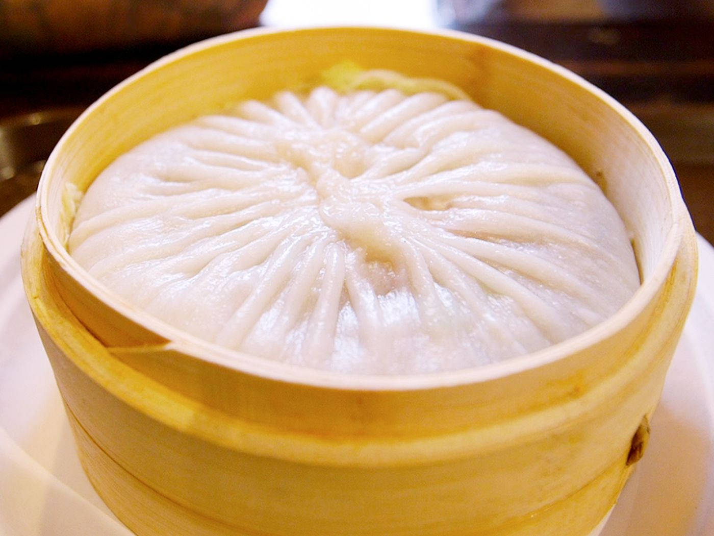steam 桌布 壁紙 — 一個完美摺疊的白色餃子正在輕木竹蒸籠中蒸煮。
